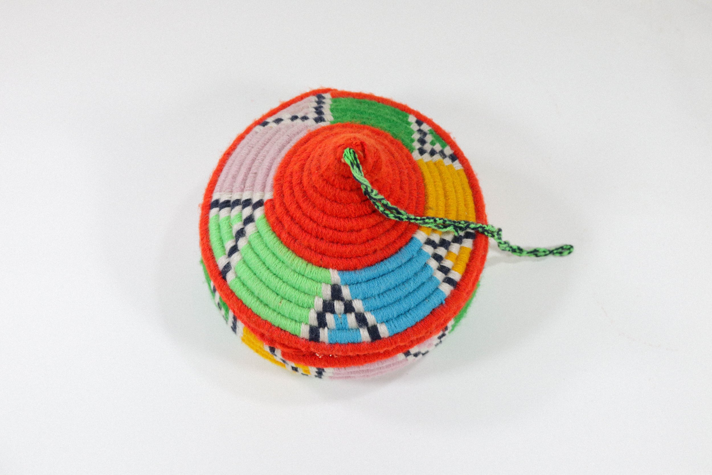 Hand-woven multicolor African hanging basket—a colorful storage solution for anywhere in the house! Lid stays on, even when basket is hung.