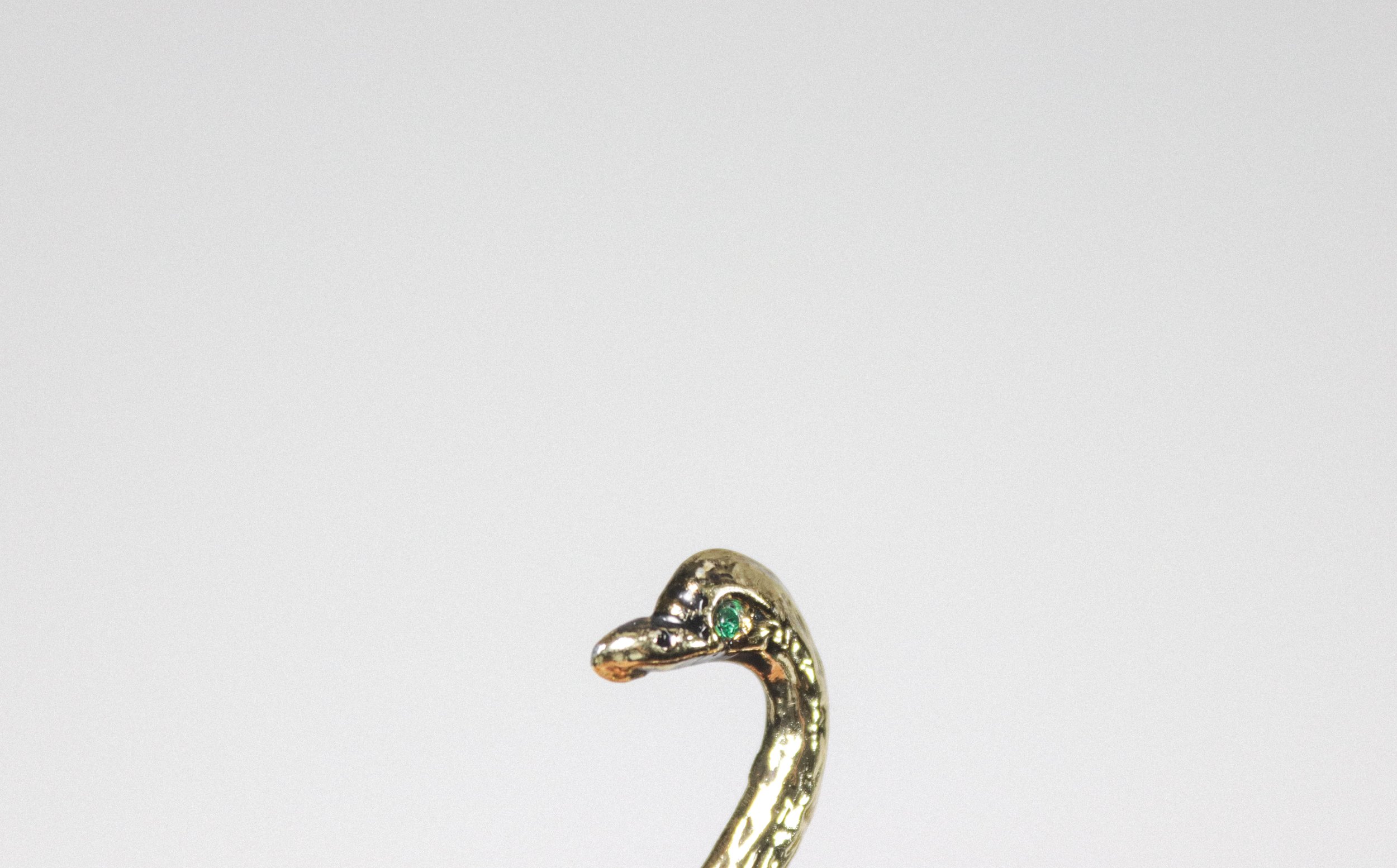 Vintage brass swan pen holder and paper weight with green eyes.