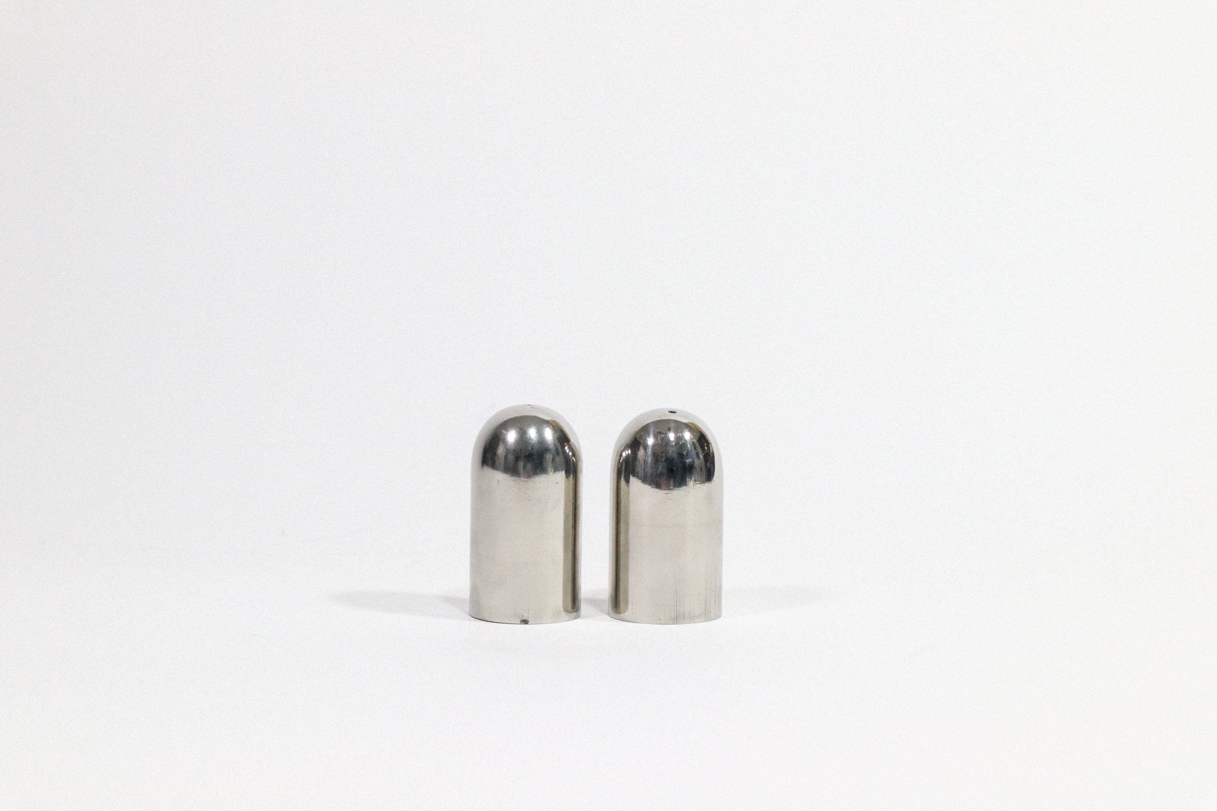Set (2) of metal bullet-shaped salt and pepper shakers.
