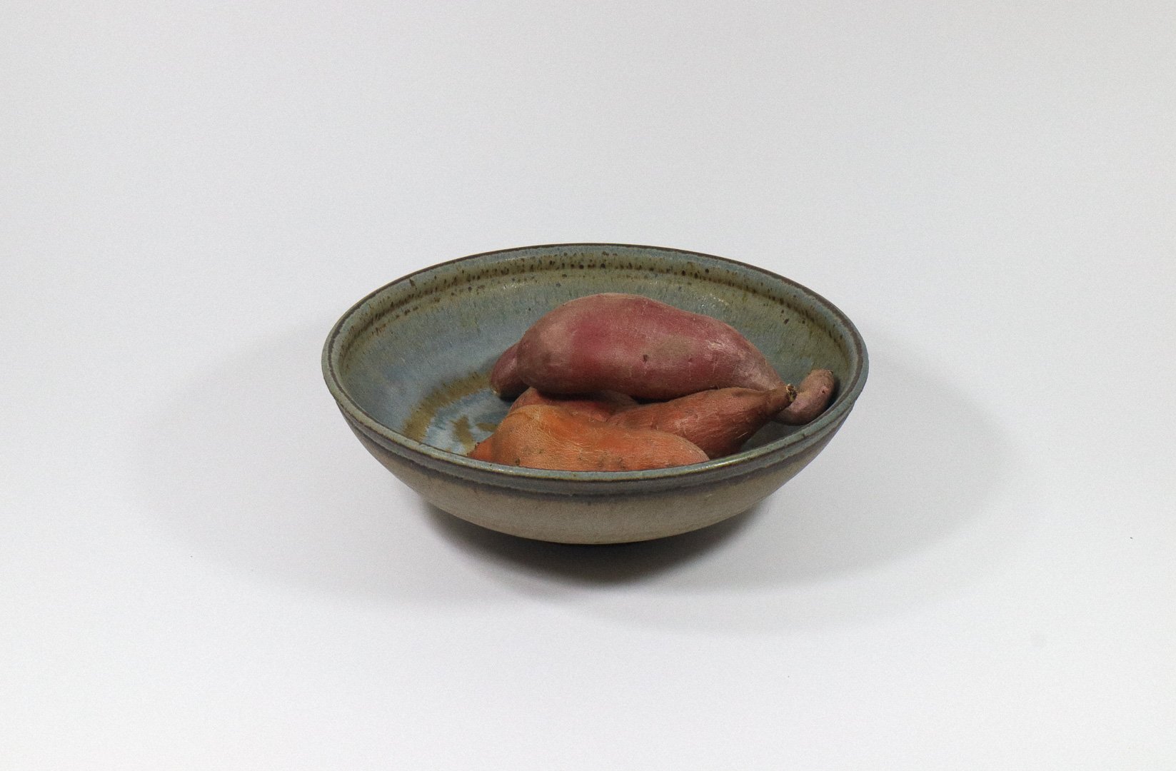 Handmade blue, gray, and brown stoneware studio bowl. Signed by artist Jack Wright on the bottom.