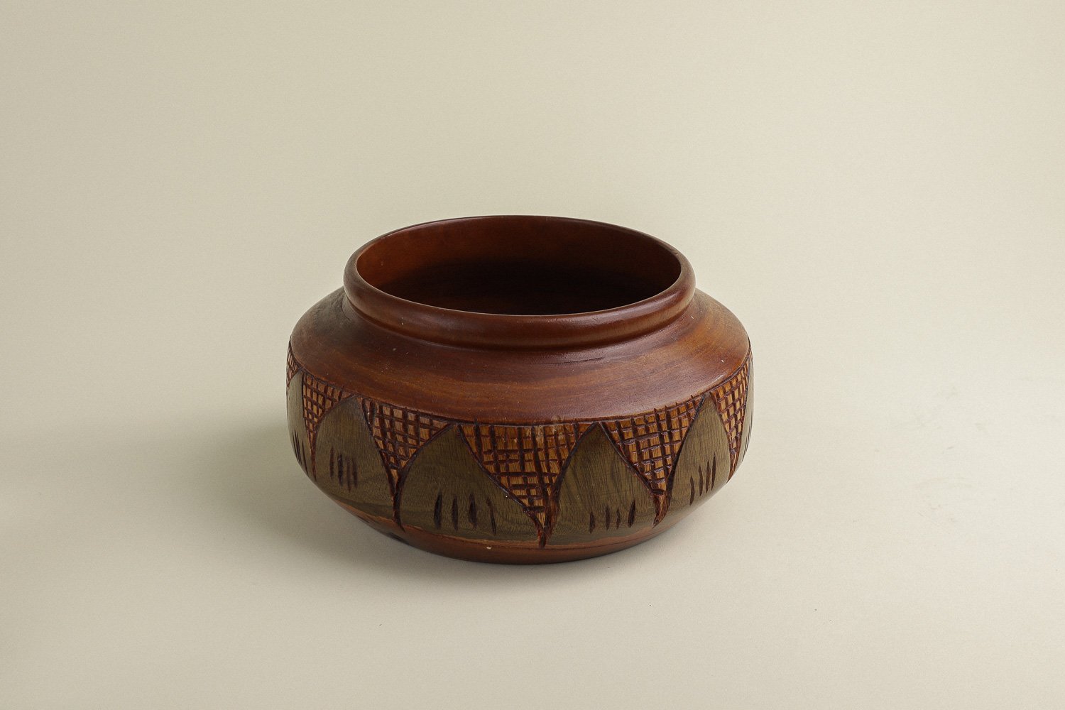 Handmade decorative wooden bowl featuring an intricate crosshatch and leaf pattern.