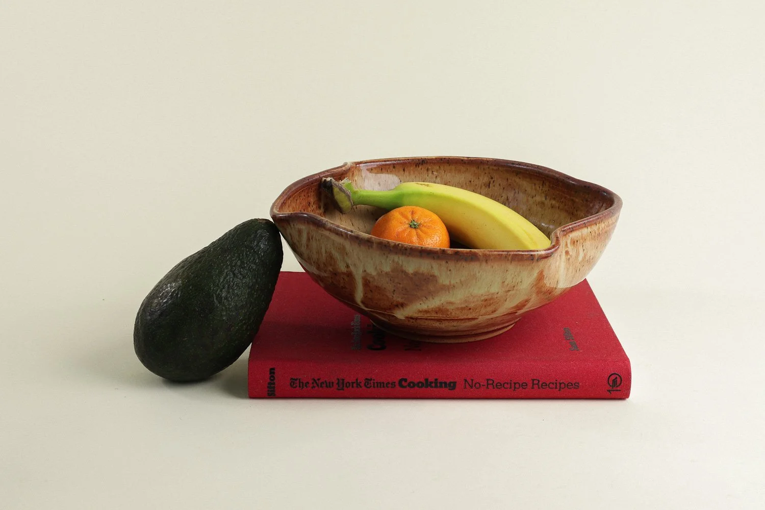 Handmade studio pottery bowl featuring a rustic, earthy-glazed swirl interior and a scalloped rim.