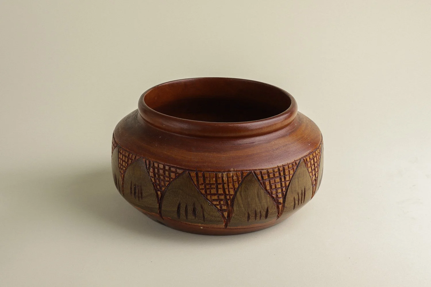 Handmade decorative wooden bowl featuring an intricate crosshatch and leaf pattern.