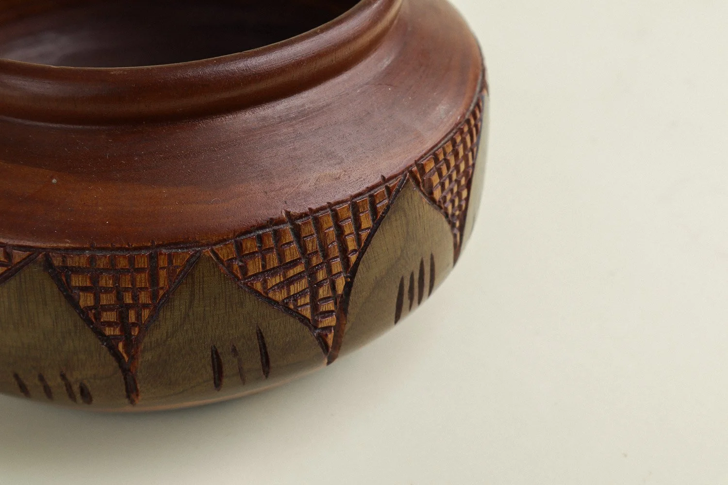 Handmade decorative wooden bowl featuring an intricate crosshatch and leaf pattern.