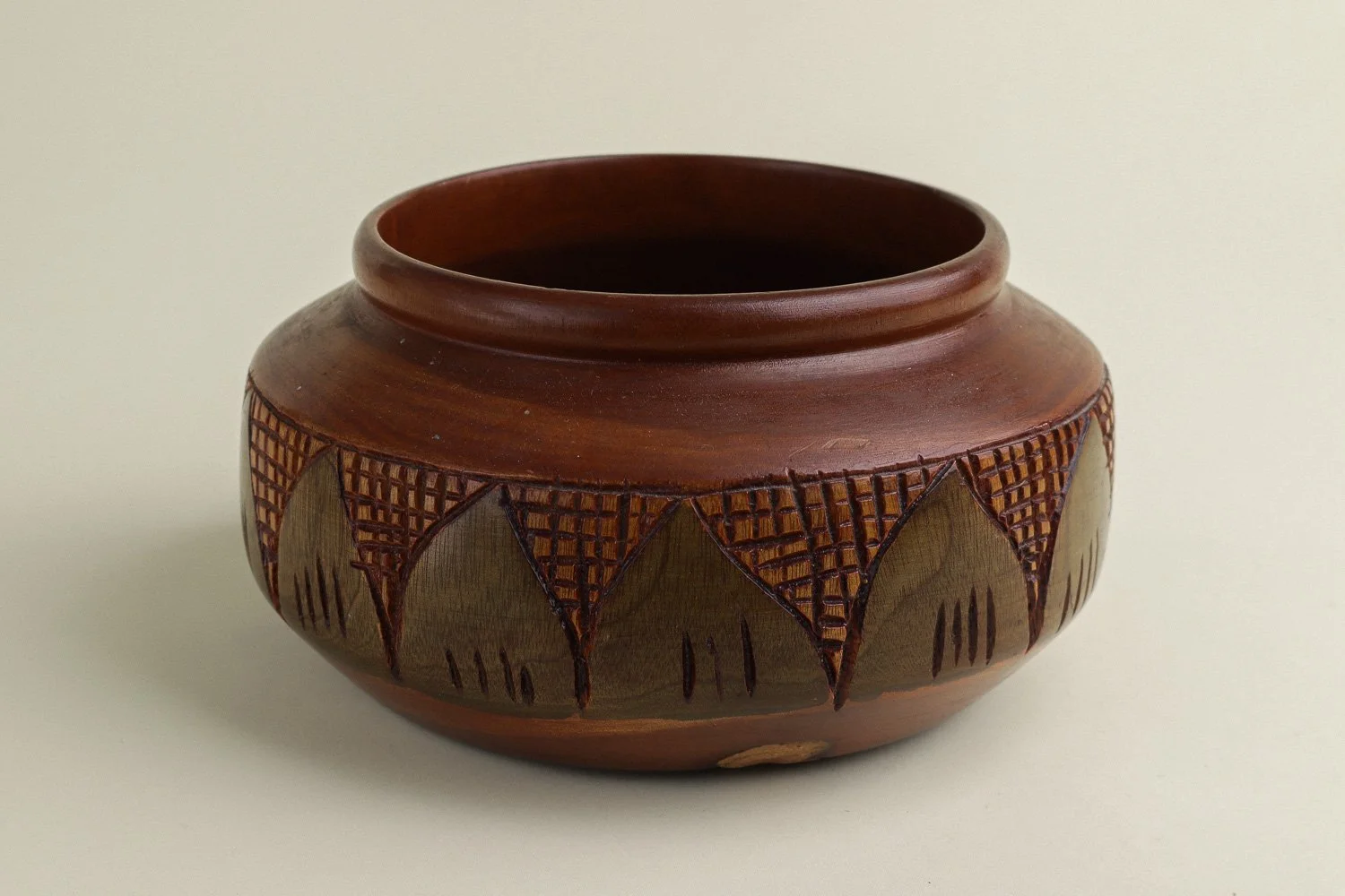 Handmade decorative wooden bowl featuring an intricate crosshatch and leaf pattern.