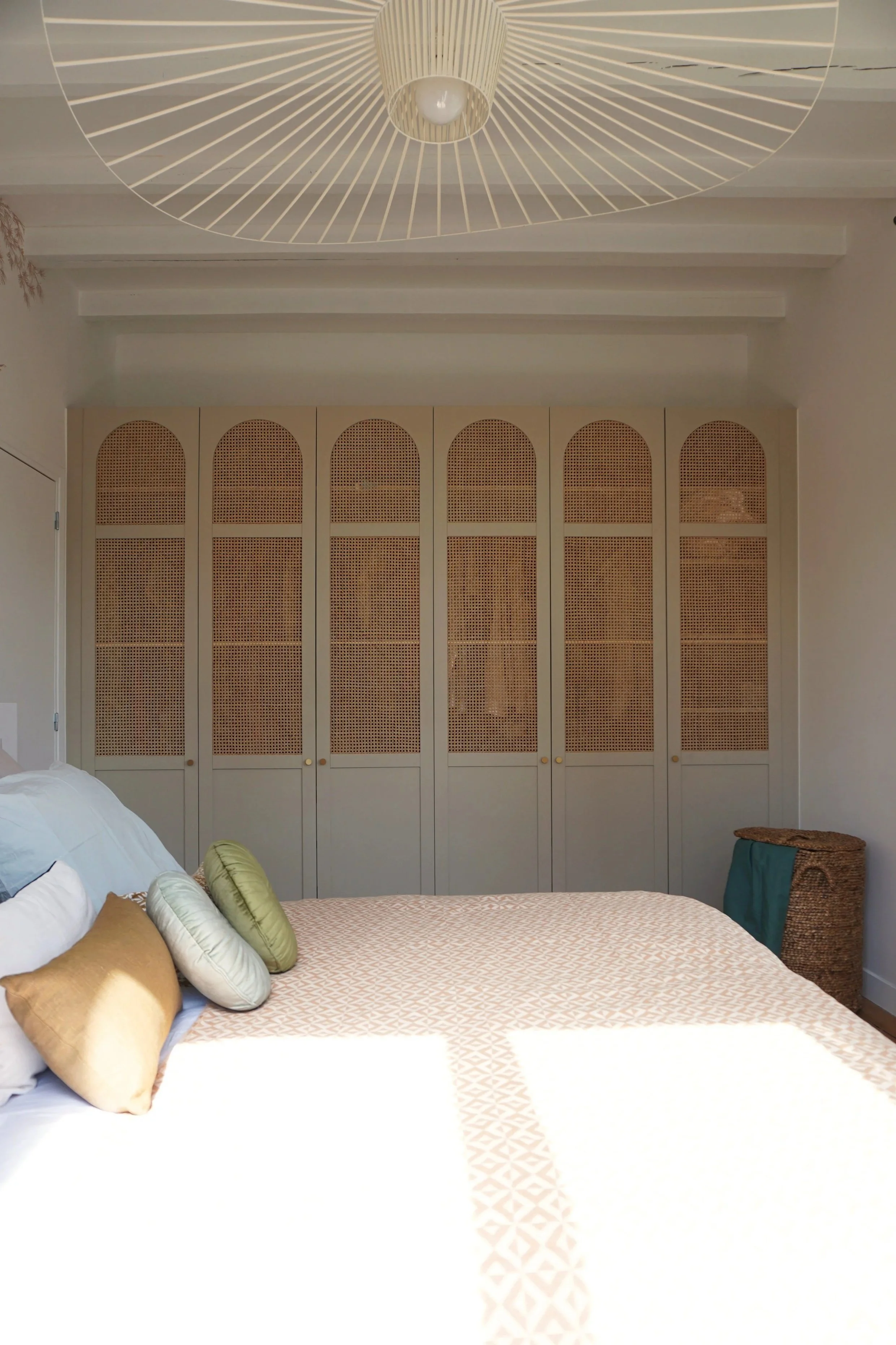 Chambre parentale papier peint bord de mer Acte Deco dressing porte cannage beige Coussins vert jaune