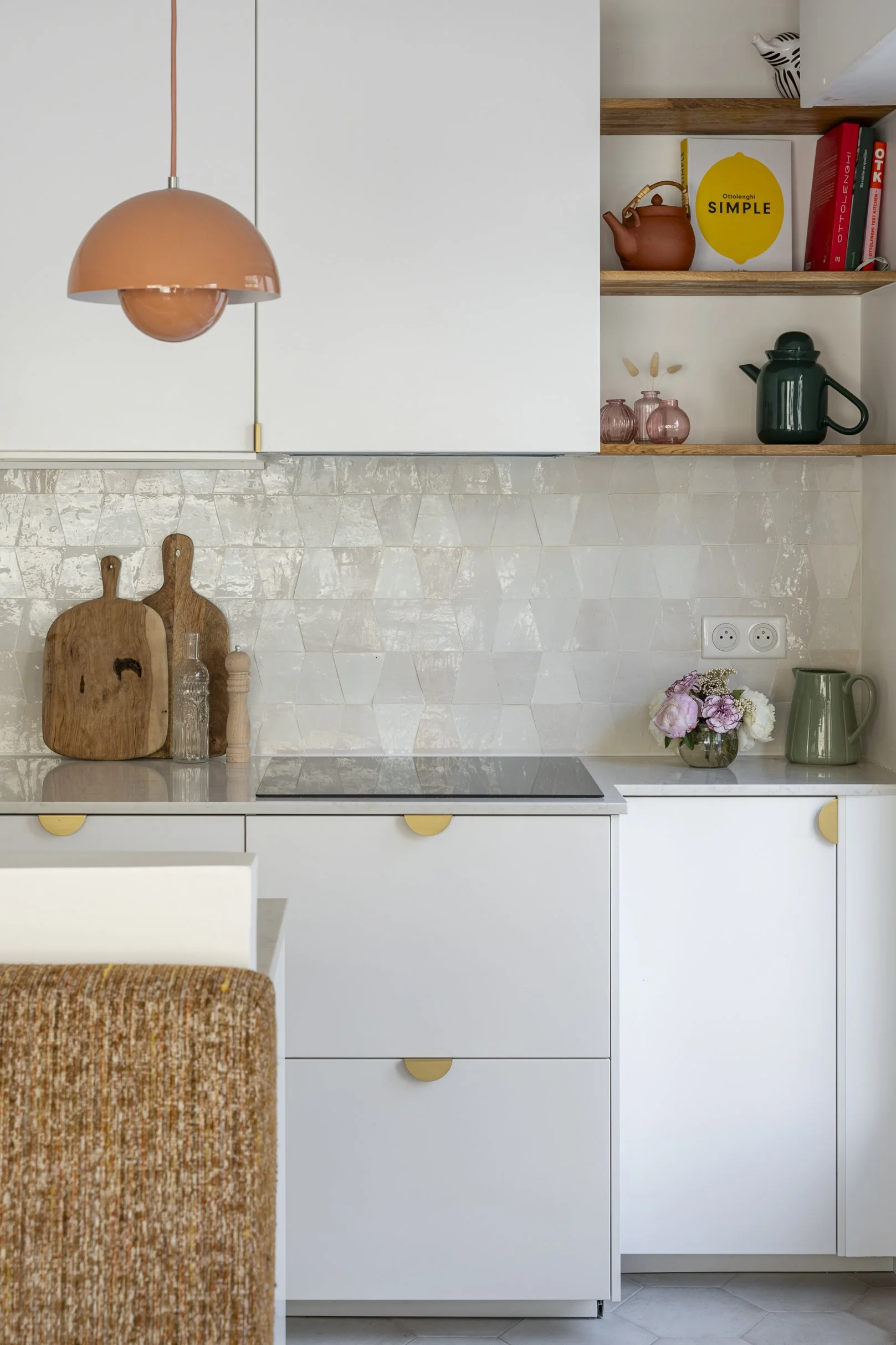 Cuisine blanche, crédence zellige beige rosé, suspension corail, banquette