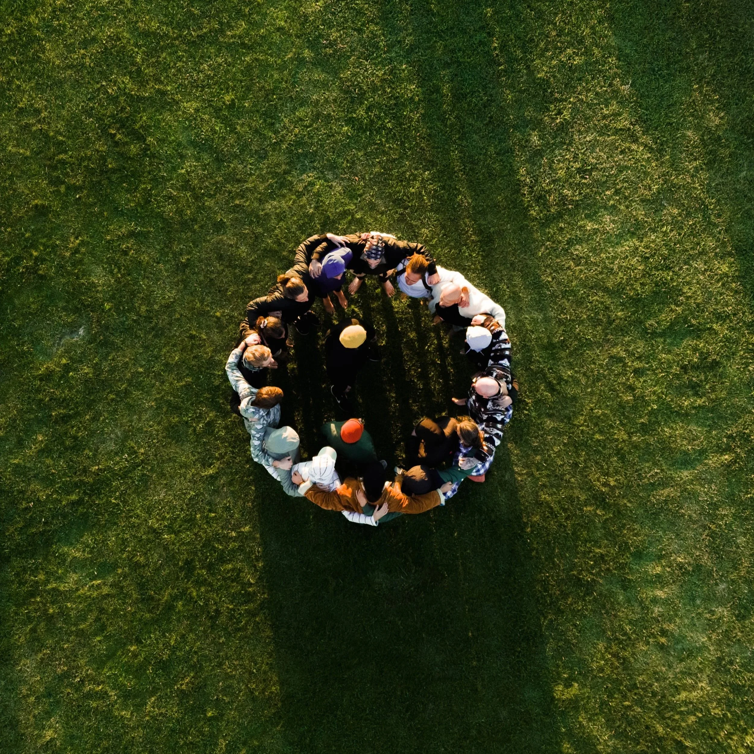Men gathered in a circle during an outdoor leadership experience facilitated by Peter Eugène Bennett