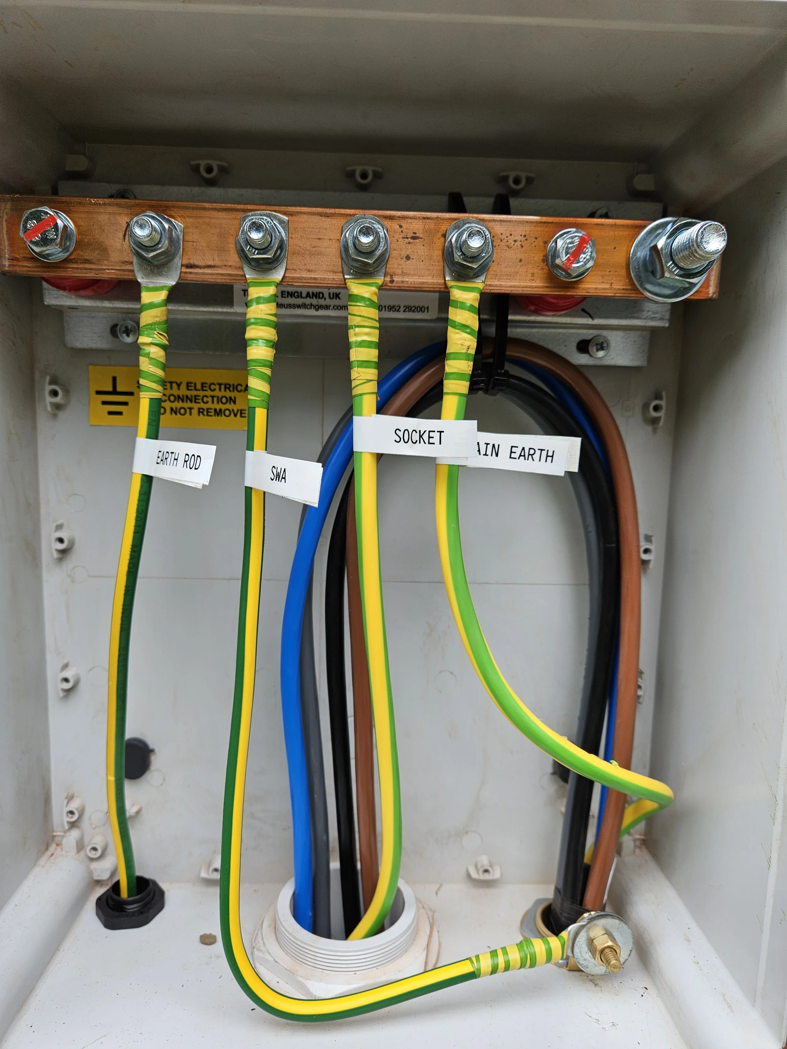 Electrical wiring inside a panel, labeled with term tags including earth rod, SWA, socket, and main earth.