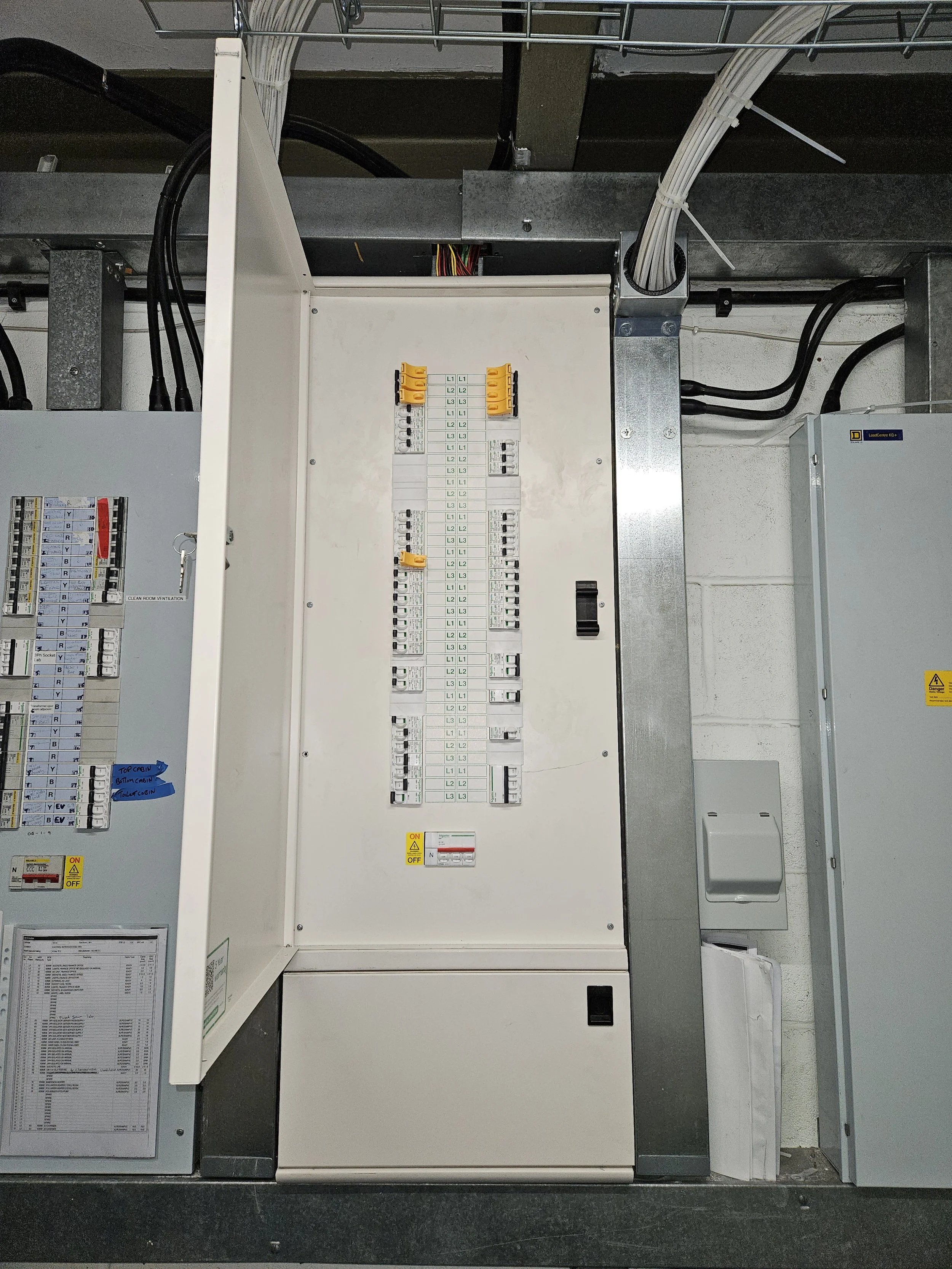An electrical panel with circuit breakers and wiring inside an industrial or commercial building.