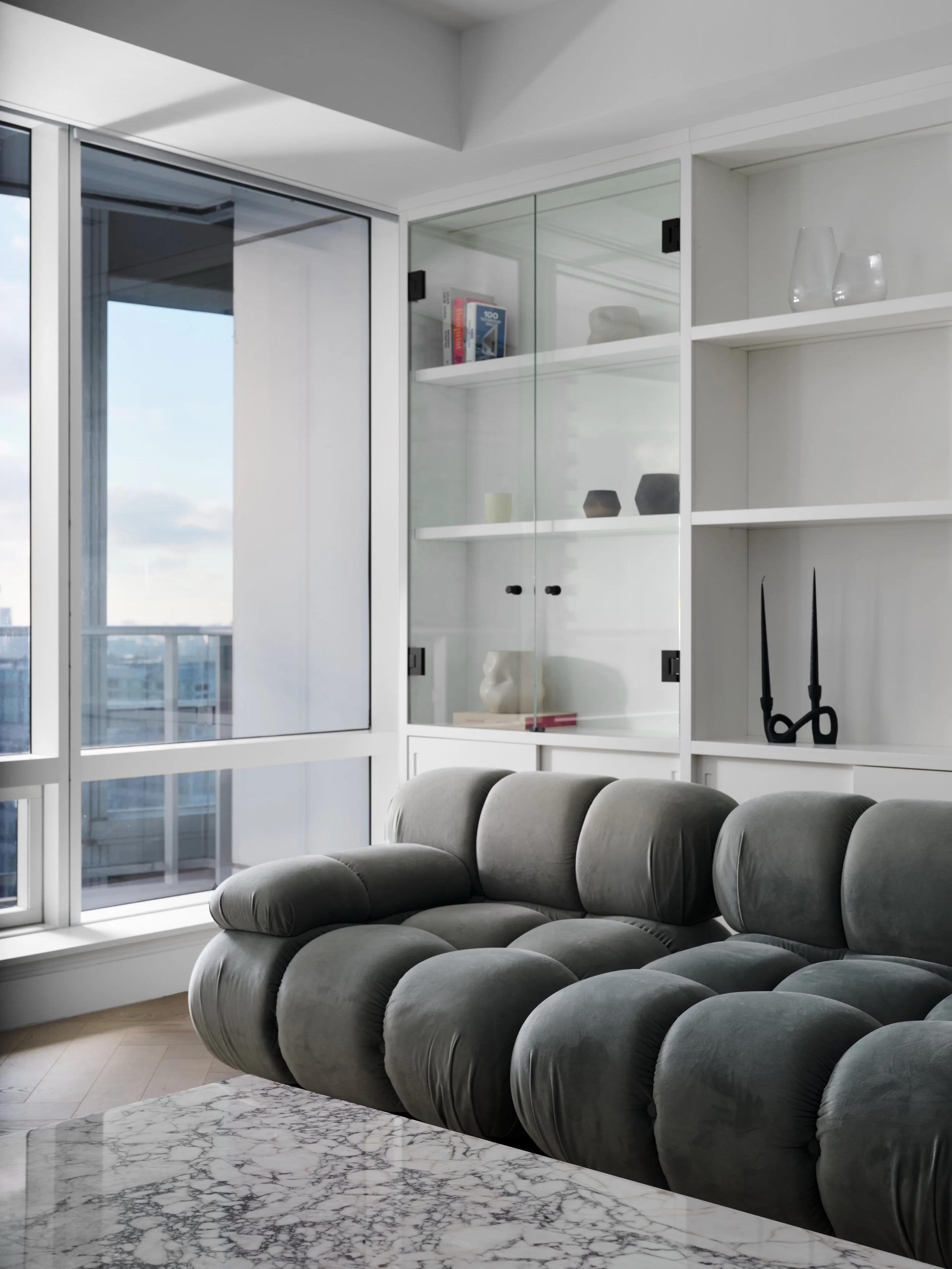 Shangri-La Residences: Living Room

A full-height integrated wall unit defines the living space &mdash; open shelving, glass display cabinets, and concealed lower storage in one continuous composition