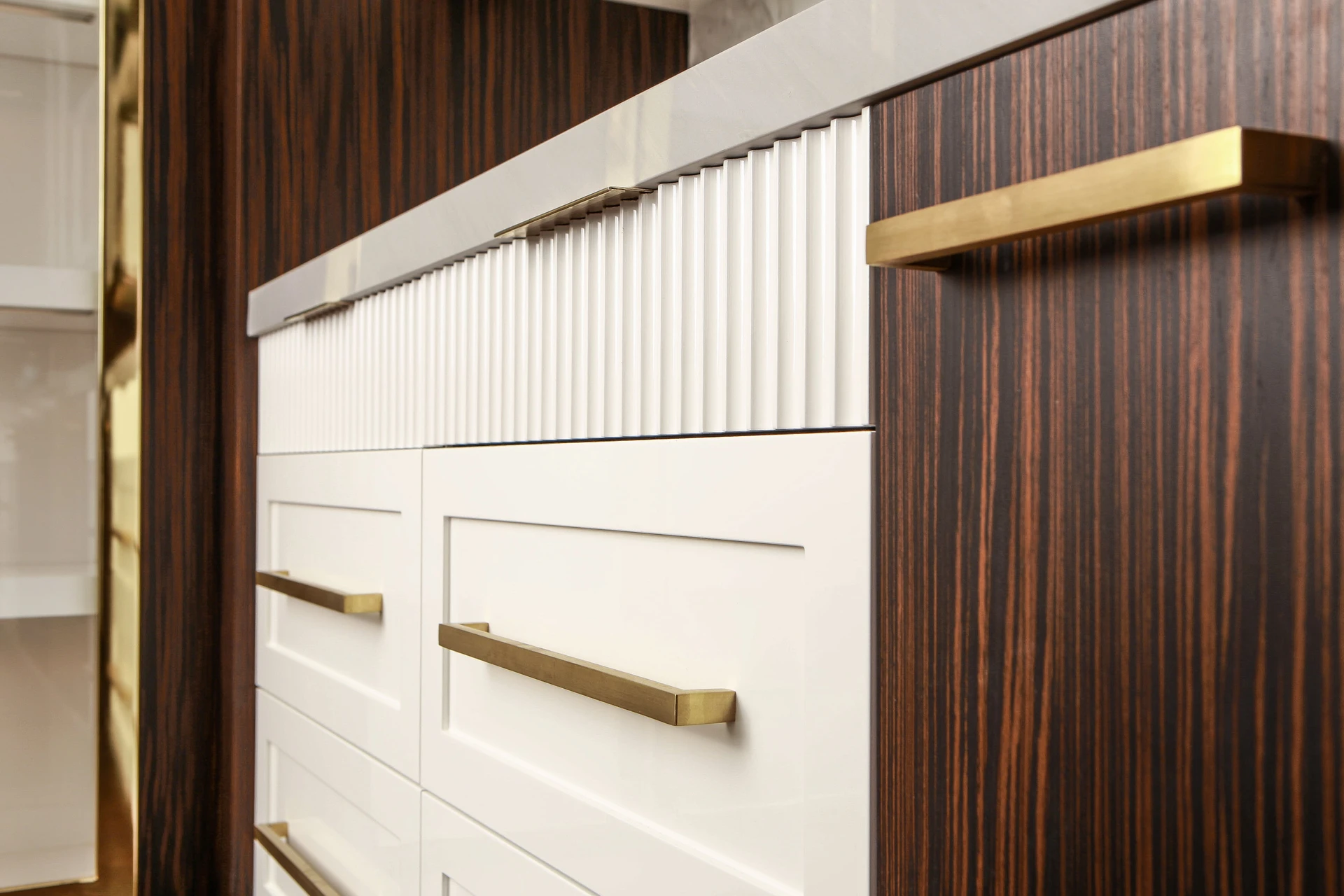 Drawer panels are painted ribbed, brass handles, macassar ebony veneer spice rack panel, Brass cabinet frame, macassar ebony veneer millwork frame