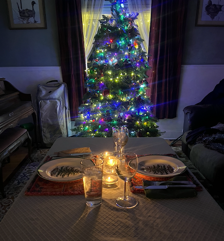 Christmas tree surrounded by candlelight symbolizing reflection, warmth, and presence