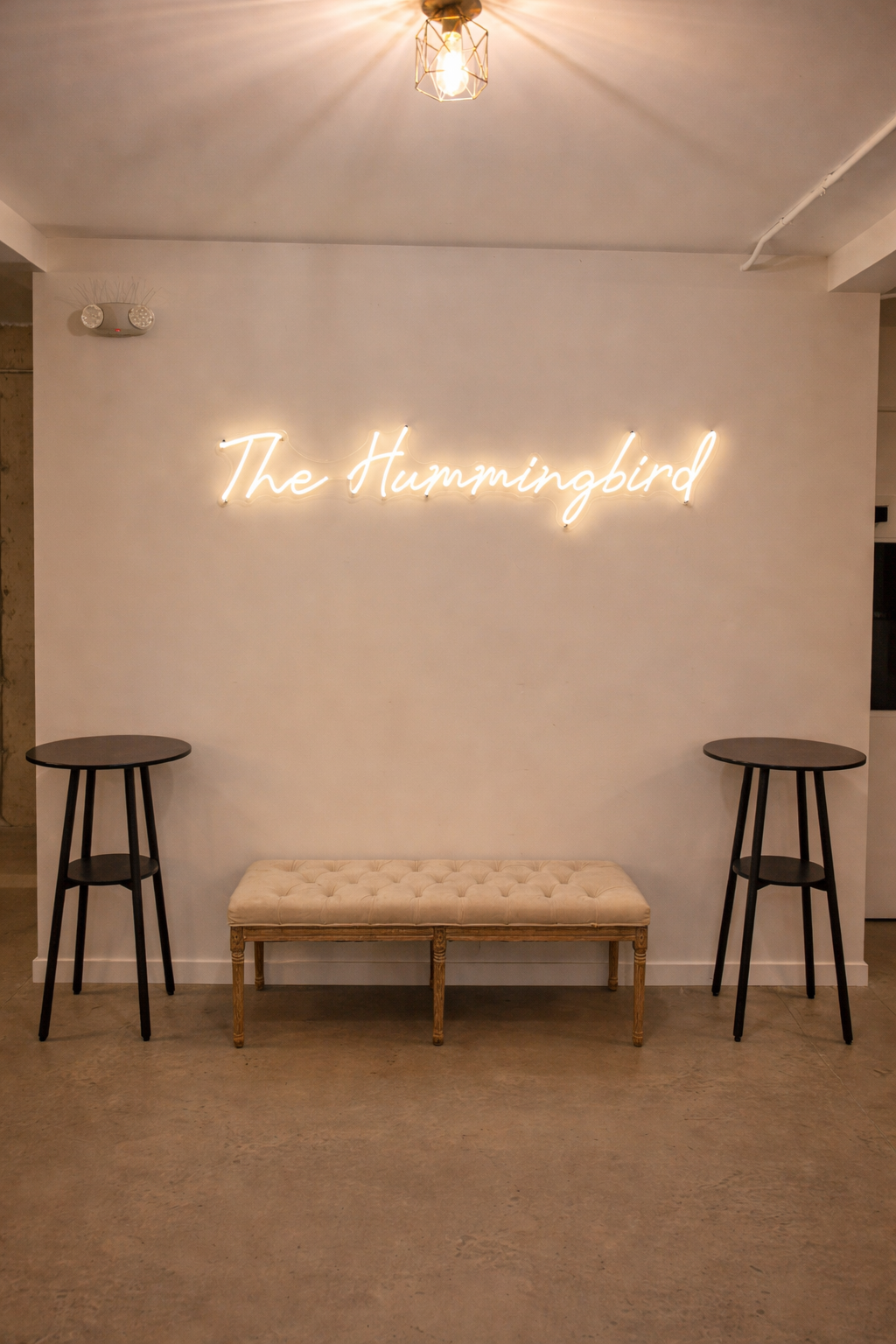 A welcoming interior moment at The Hummingbird in Erin, Ontario, featuring the venue’s signature neon sign displayed against a clean, modern backdrop. This stylish space offers a warm first impression and a favourite photo moment for guests as they a