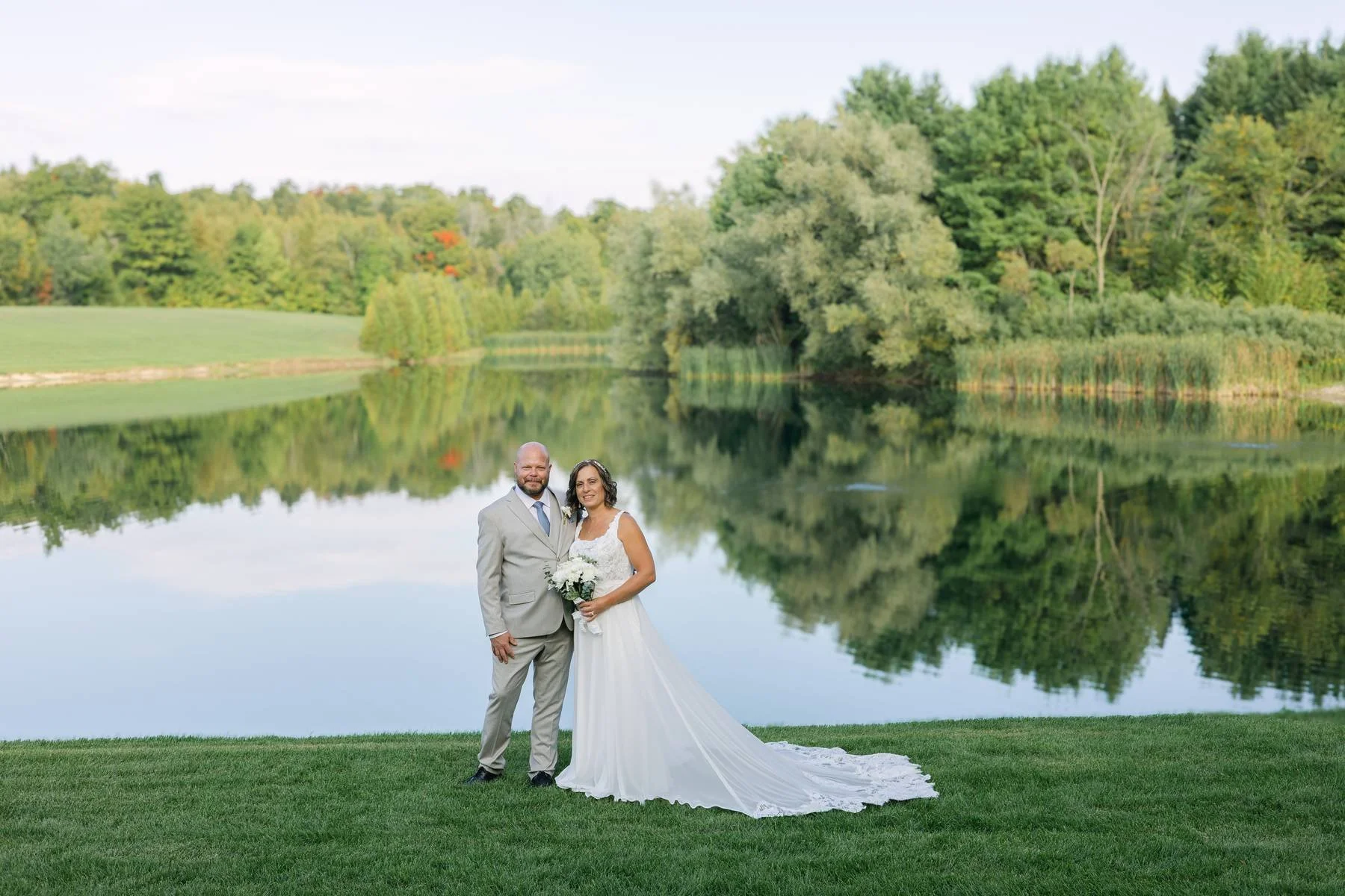 Wedding couple portrait by the pond at The Hummingbird in Erin, Ontario, featuring scenic water views, rolling countryside, and a peaceful outdoor ceremony backdrop.