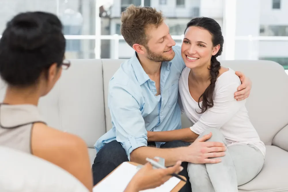 Couple attending a couples therapy session to strengthen communication while navigating parenting stress and family pressure.