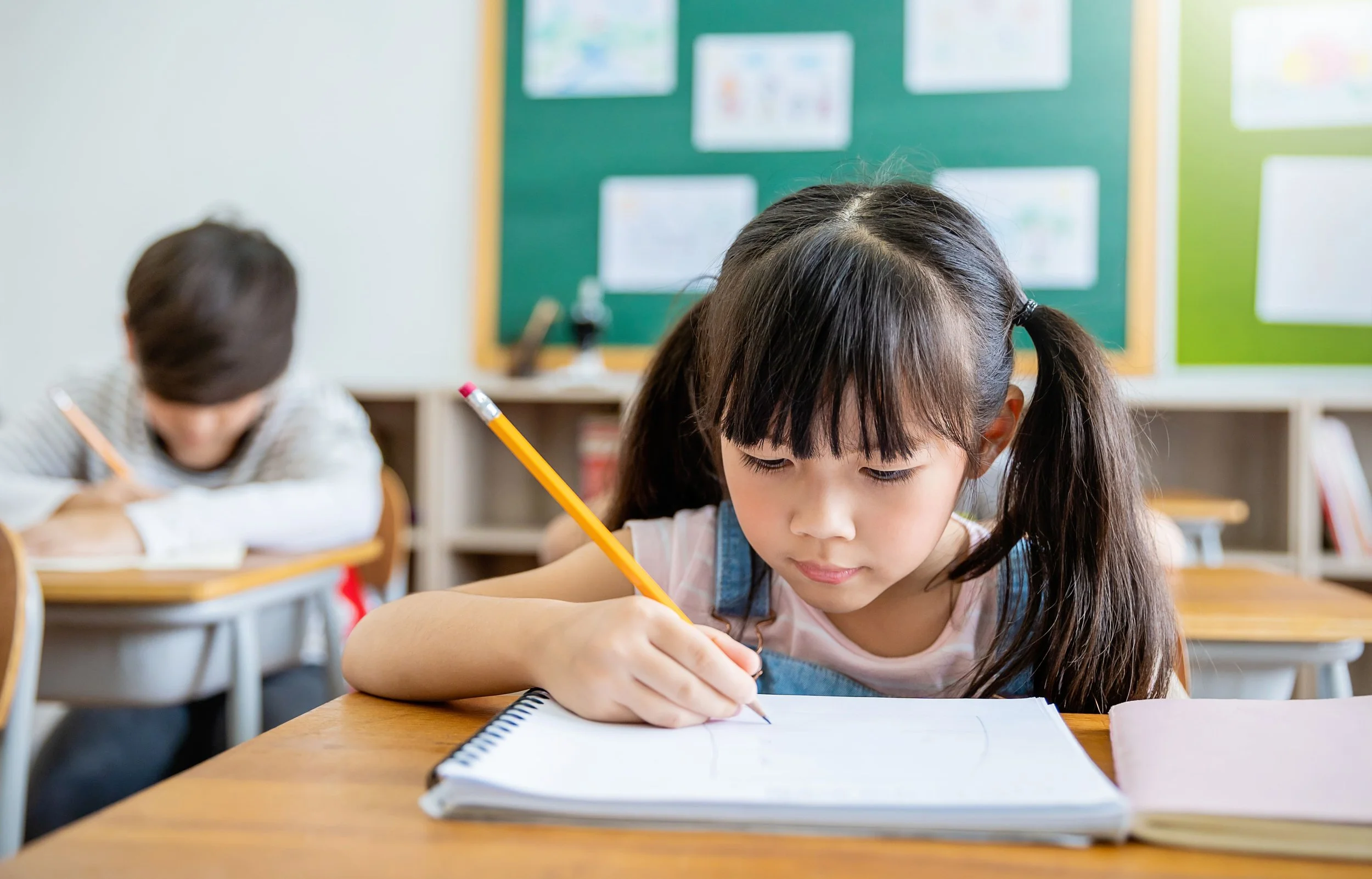 young asian pupil studying inside a classroom