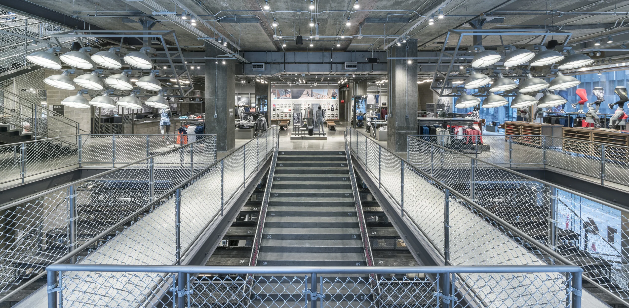 Central staircase and mezzanine overview inside Adidas Flagship NYC retail space