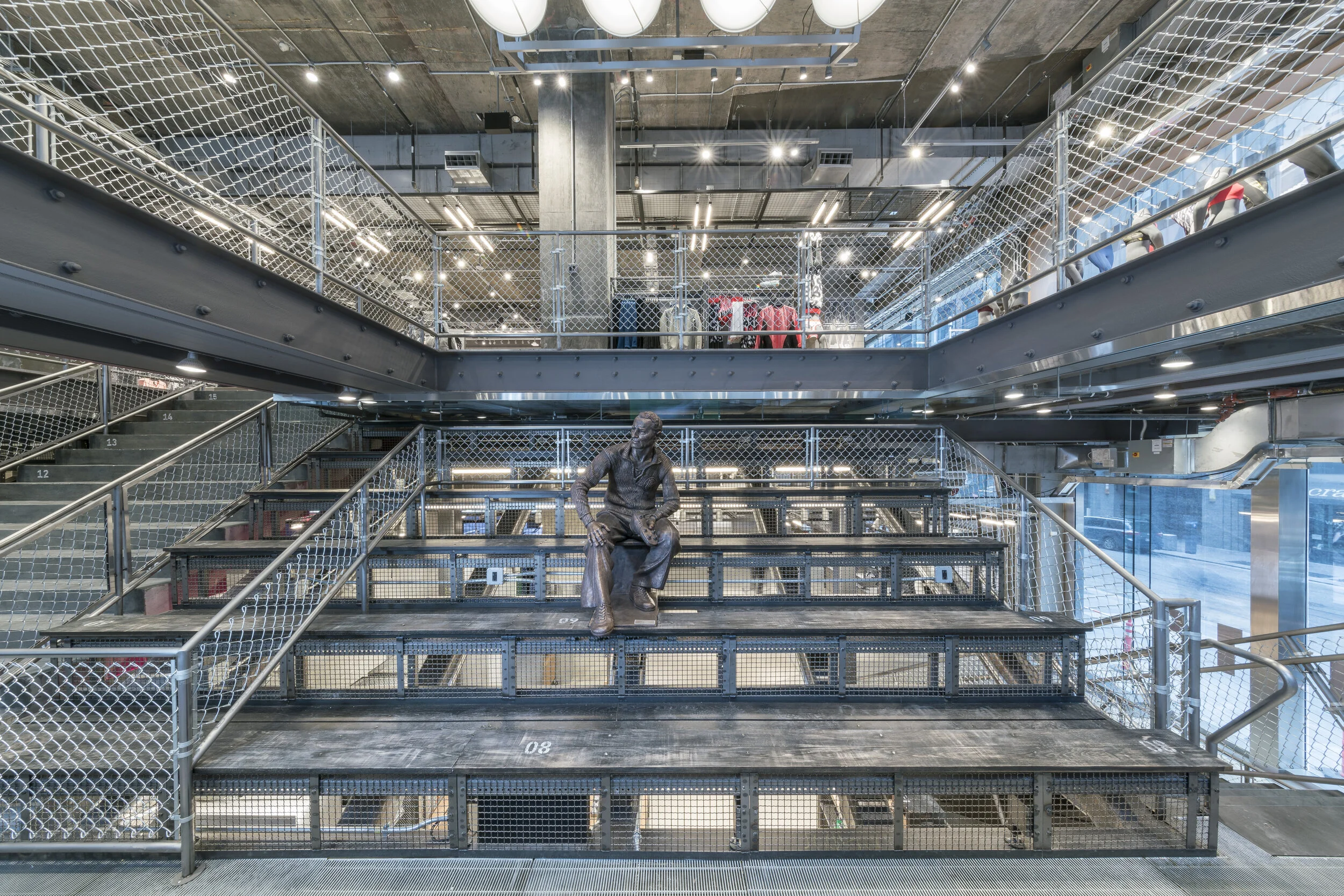 Wide angle overview of bleacher seating with sculptural installation inside Adidas Flagship NYC