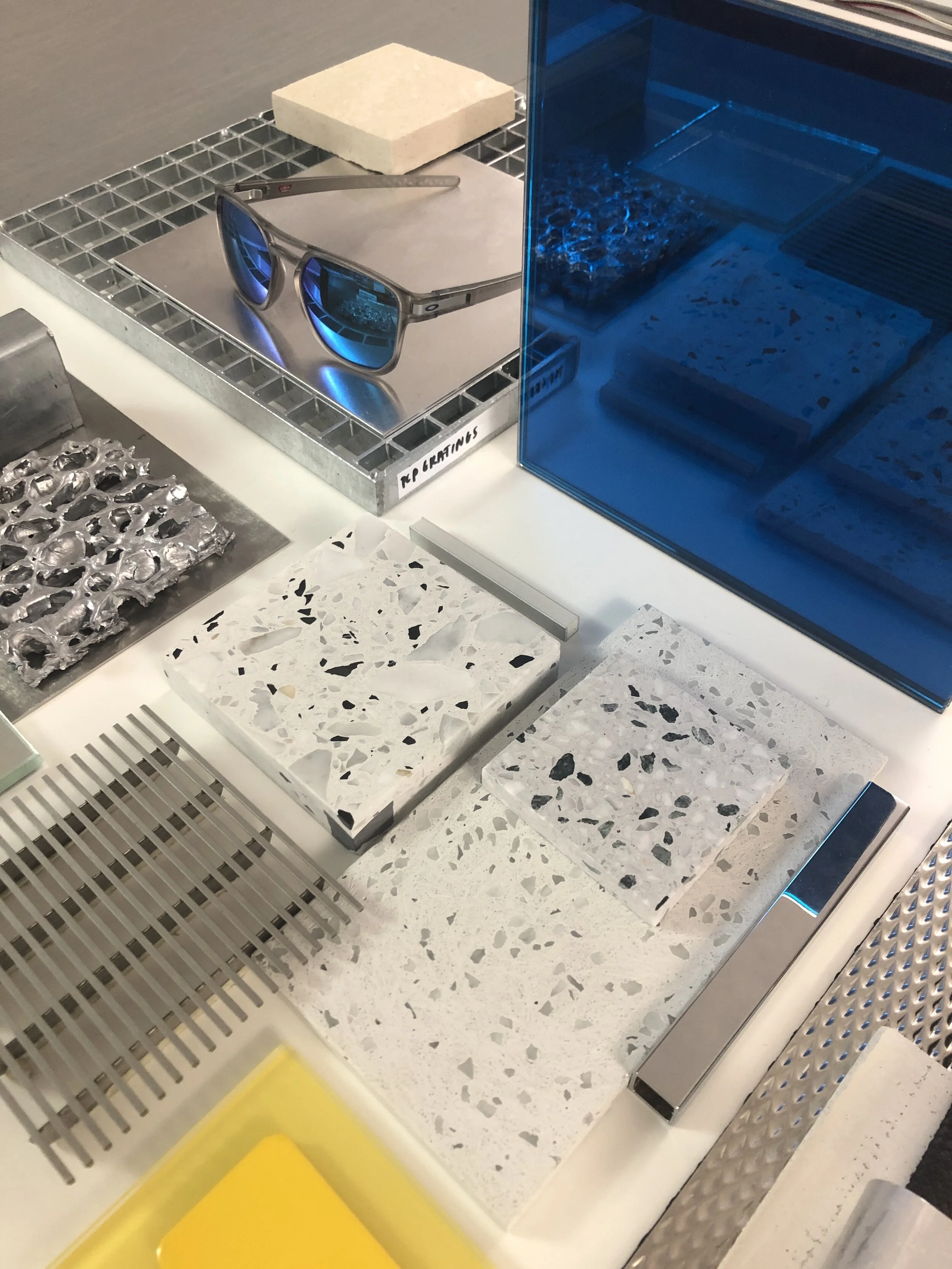 Oakley flagship store Shibuya Japan material sample display featuring terrazzo, metal grating, glass panels, and industrial finishes.
