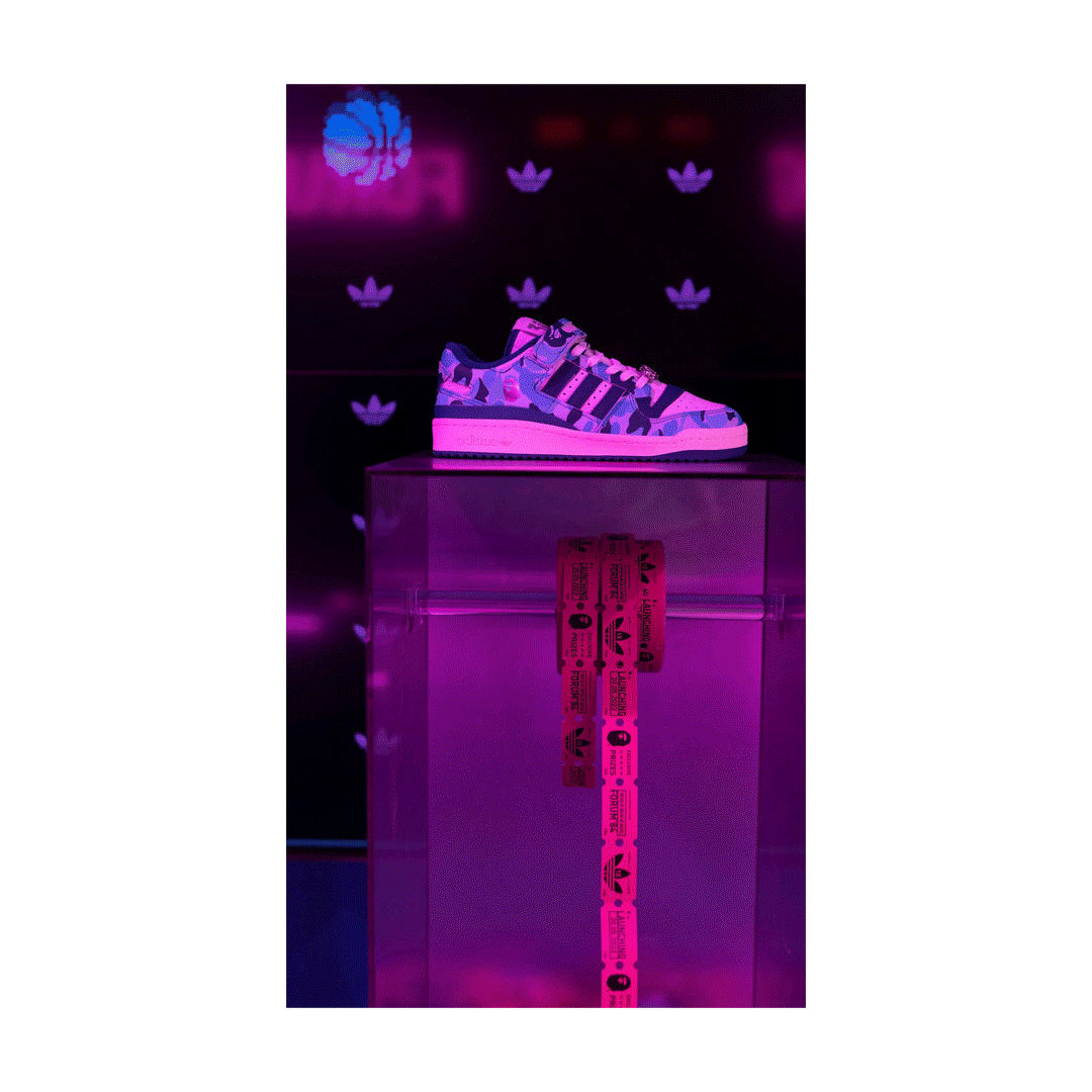 Adidas x BAPE camo Superstar sneaker displayed on a neon pink plinth inside the END London pop-up installation.