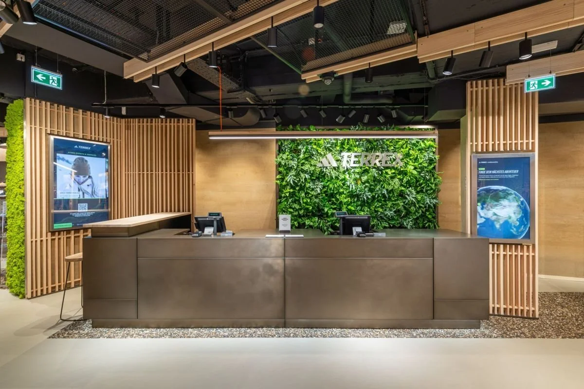 Adidas Terrex Munich service counter featuring a living green wall and Terrex branding.