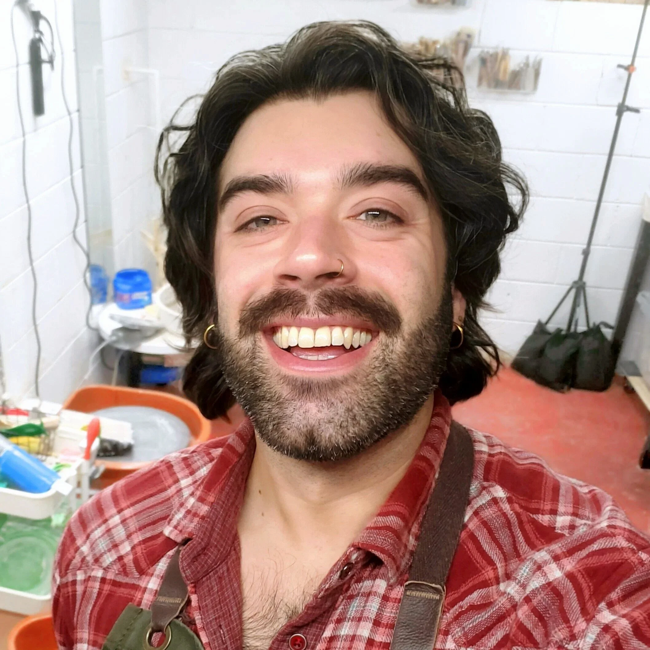 A smiling man in a pottery studio. Two Ships Pottery in Charlotte, NC is the most fun and unique date night experience and is LGBTQ+ friendly and welcoming. Owned by gay, local Charlotte ceramic artist Arias DeRienzoma