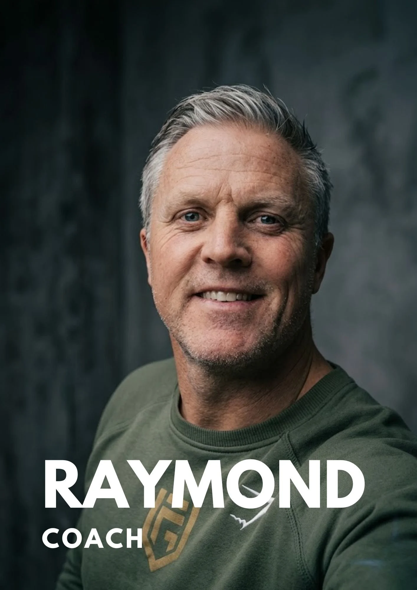 A middle-aged man with gray hair smiling, wearing a green shirt with a logo, in front of a dark background with the text 'RAYMOND' and 'COACH' overlayed.