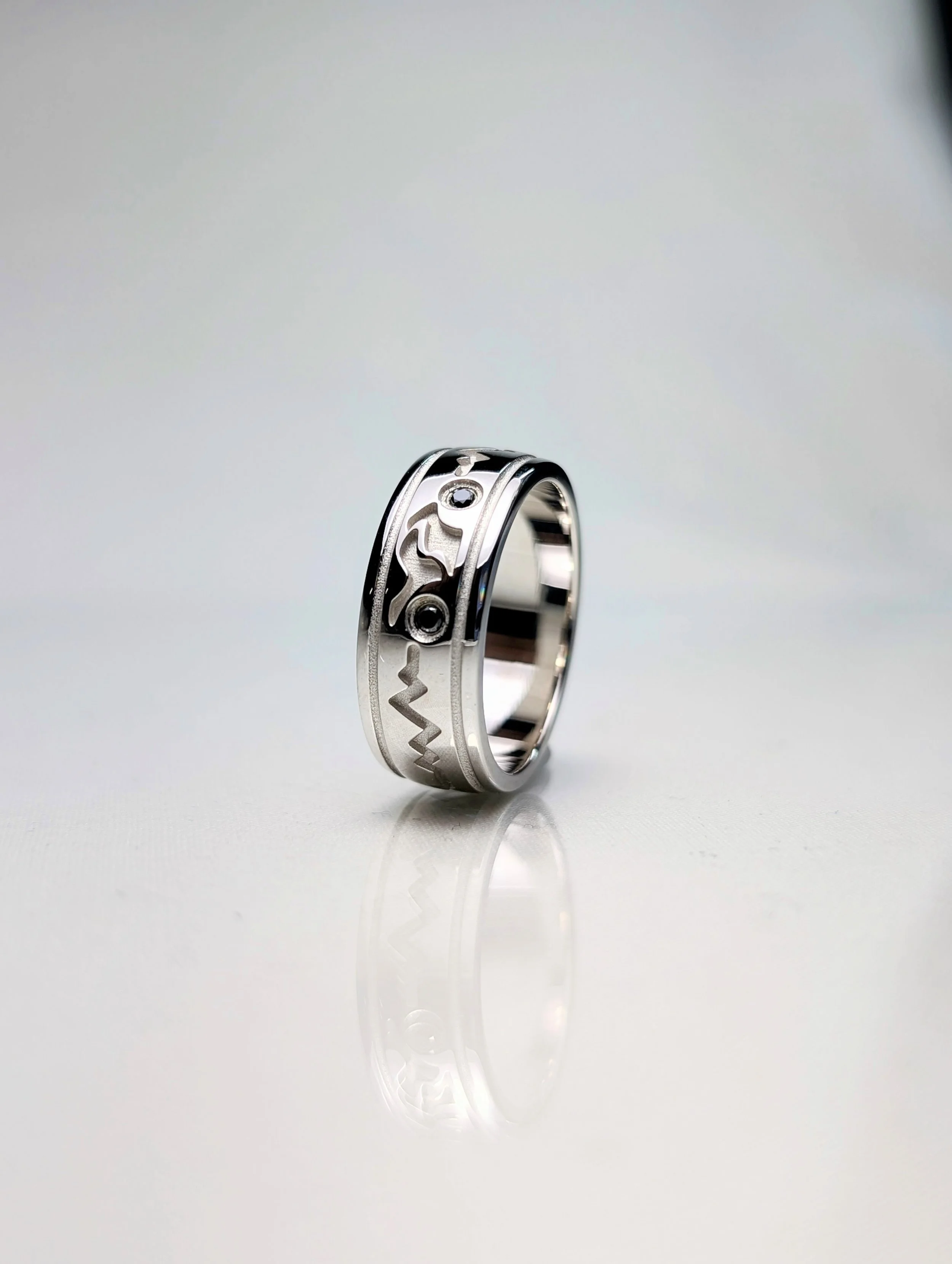 Gents 14kt white gold Motorcycle cut out heart beat ring featuring 2 round brilliant cut black diamonds as the wheels