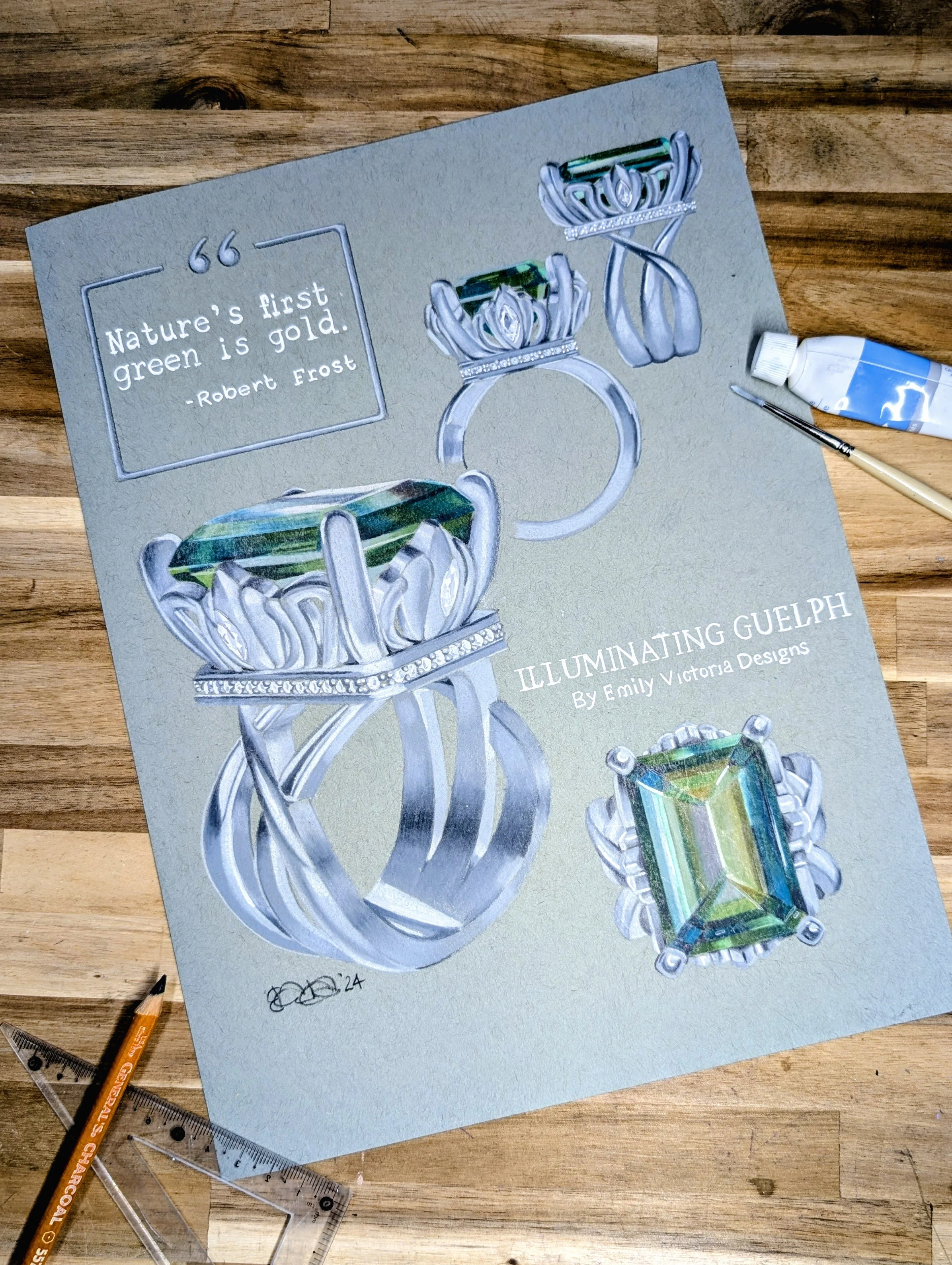 A hand-painted illustration of jewelry featuring a  ring with a green gemstone, accompanied by text about illuminating Guelph. The painting is on textured paper placed on a wooden surface with tools nearby.