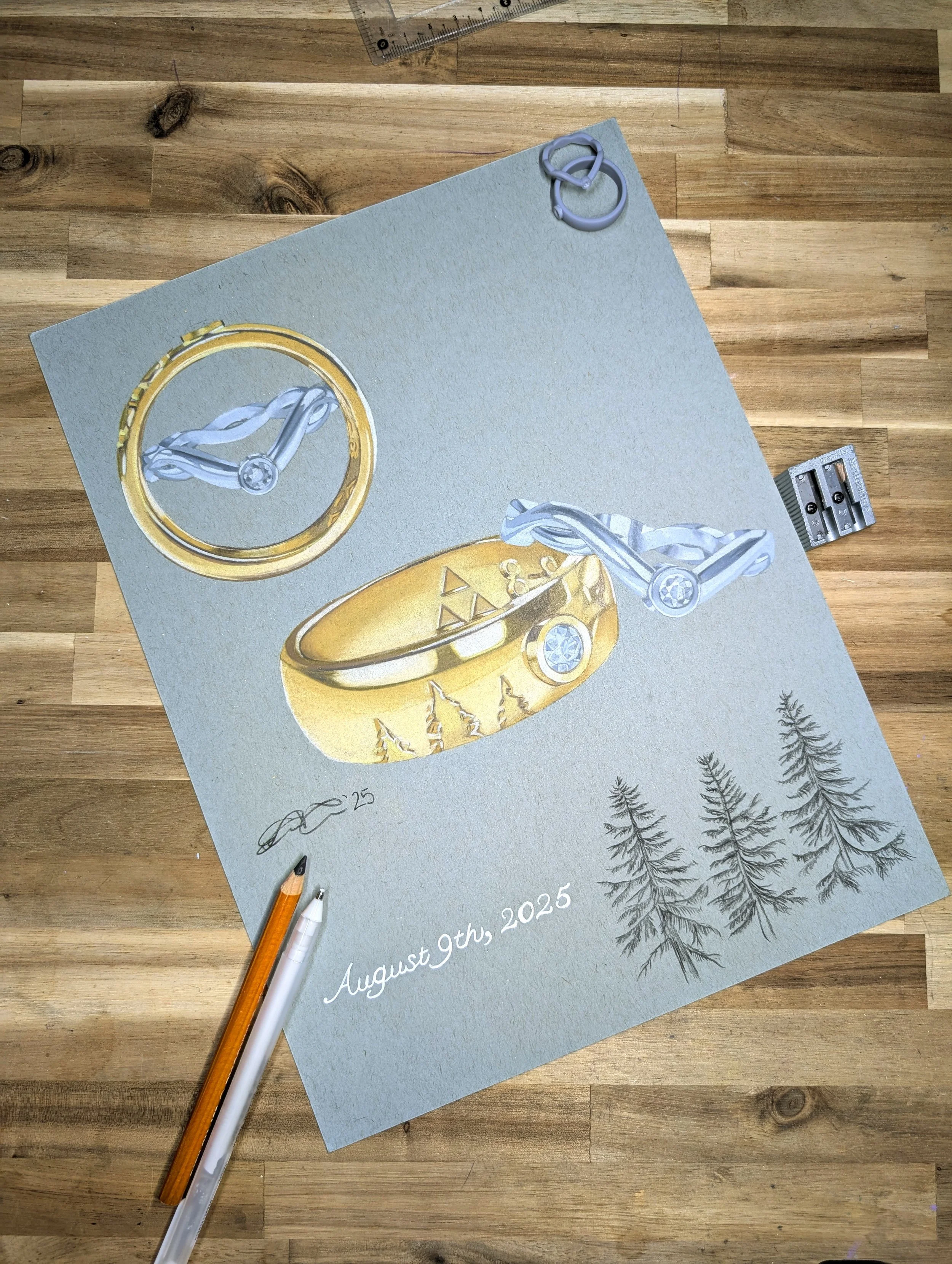 Illustration of two gold wedding rings and a diamond on light blue paper with evergreen trees, a signature, and the date August 9th, 2025, on a wooden surface.