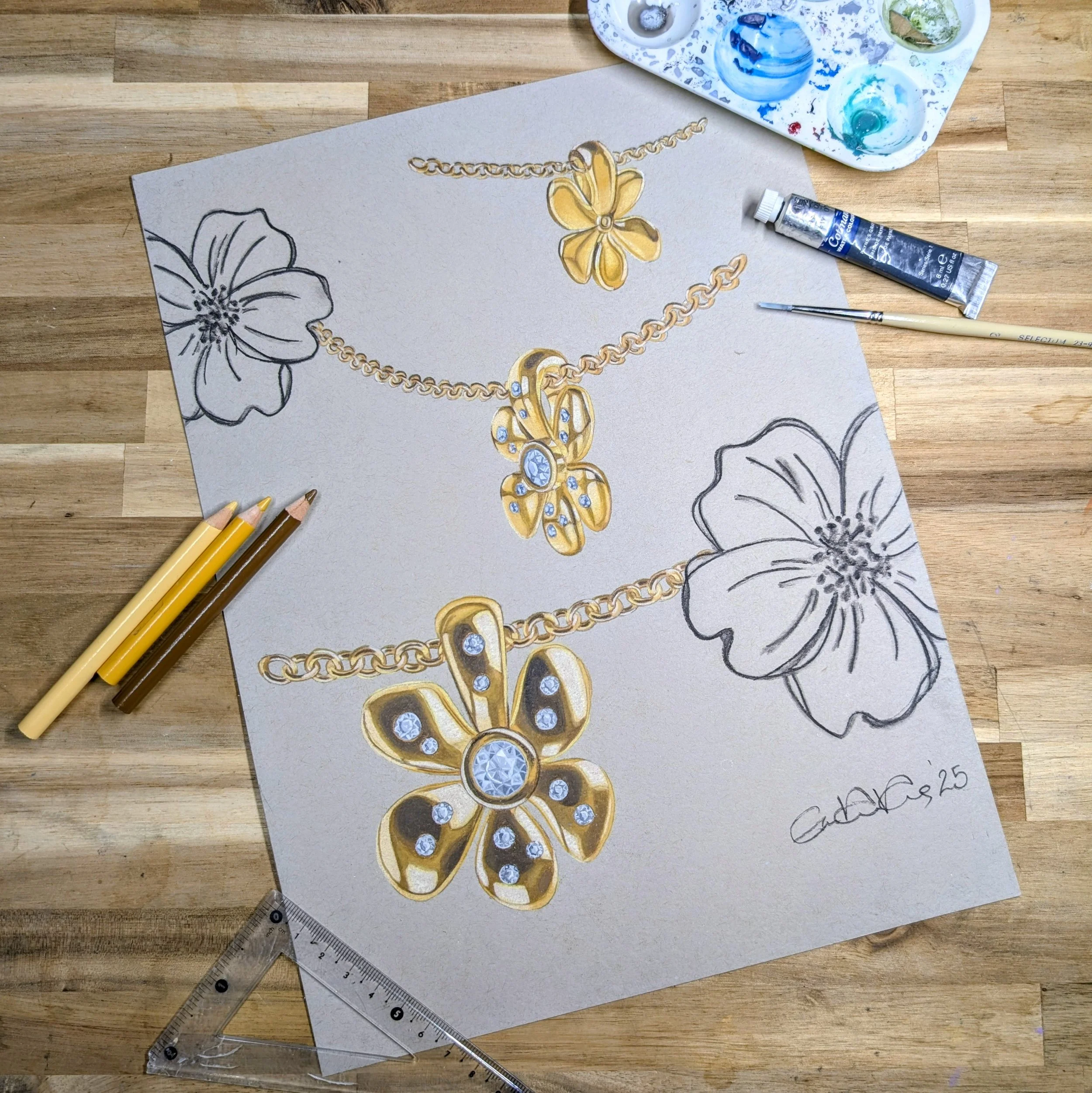 Drawing of gold jewelry including a necklace and a pendant on a sketchpad with floral illustrations, colored pencils, and art supplies on a wooden surface.