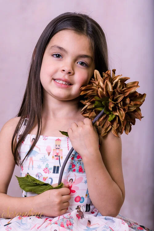 5+year+old+girl+in+the+nutcracker+ballet+tutu+holding+a+flower+to+her+face-4861.jpg