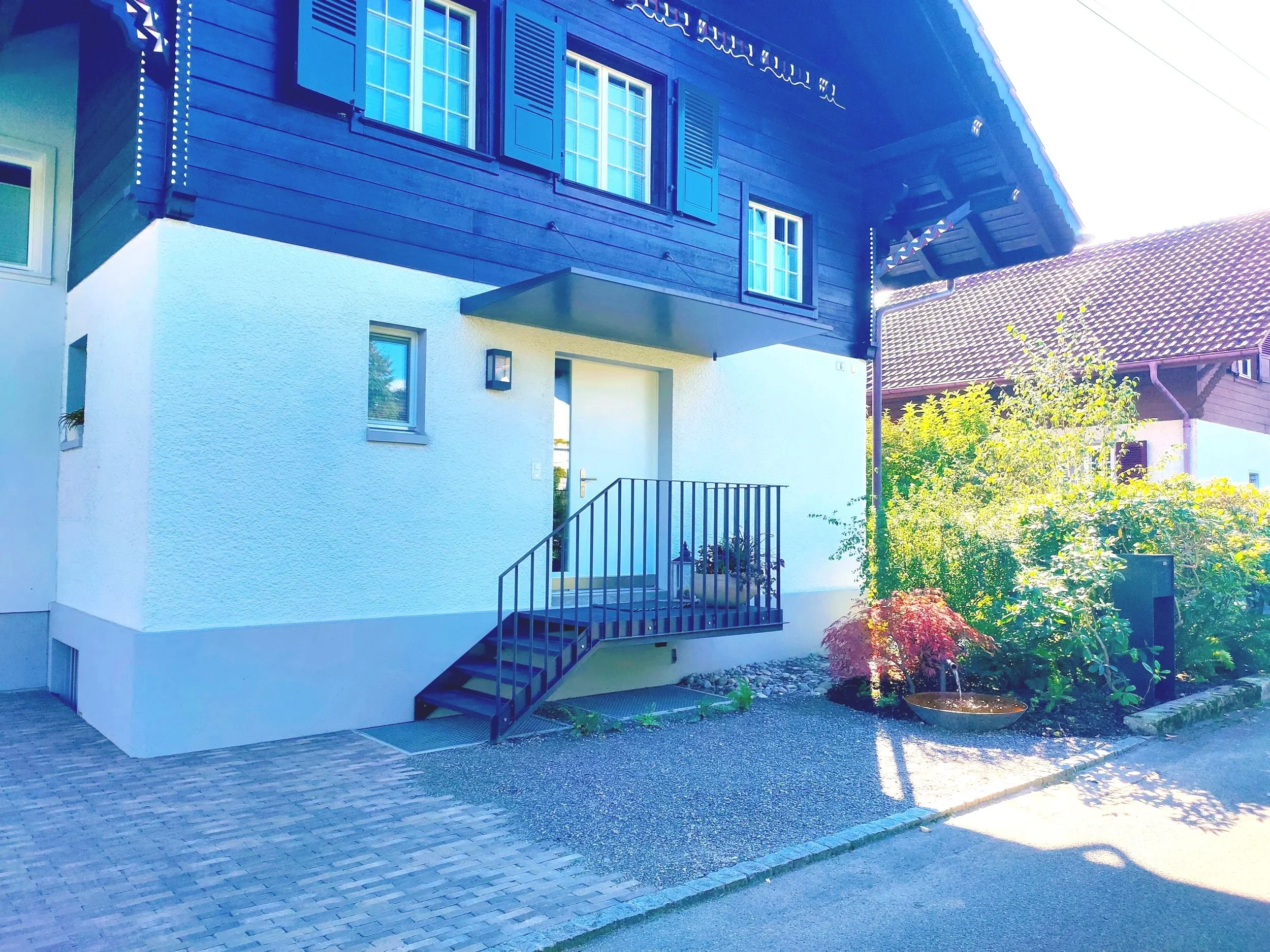 Einfahrt, Eingangsbereich, Klinker Bodenbelag passend zu alten Chalet,Brunnen mit Begrünung, Umbau Thun,Bern