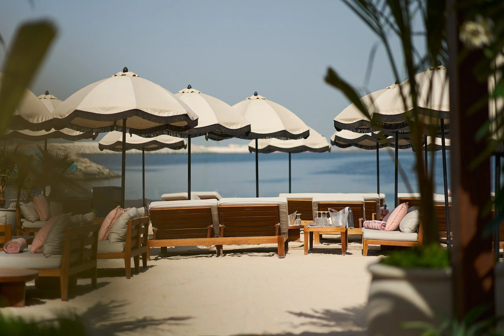 The entrance to GITANO DUBAI at J1 Beach, lined with palms and tropical greenery leading to a chic beachfront oasis.