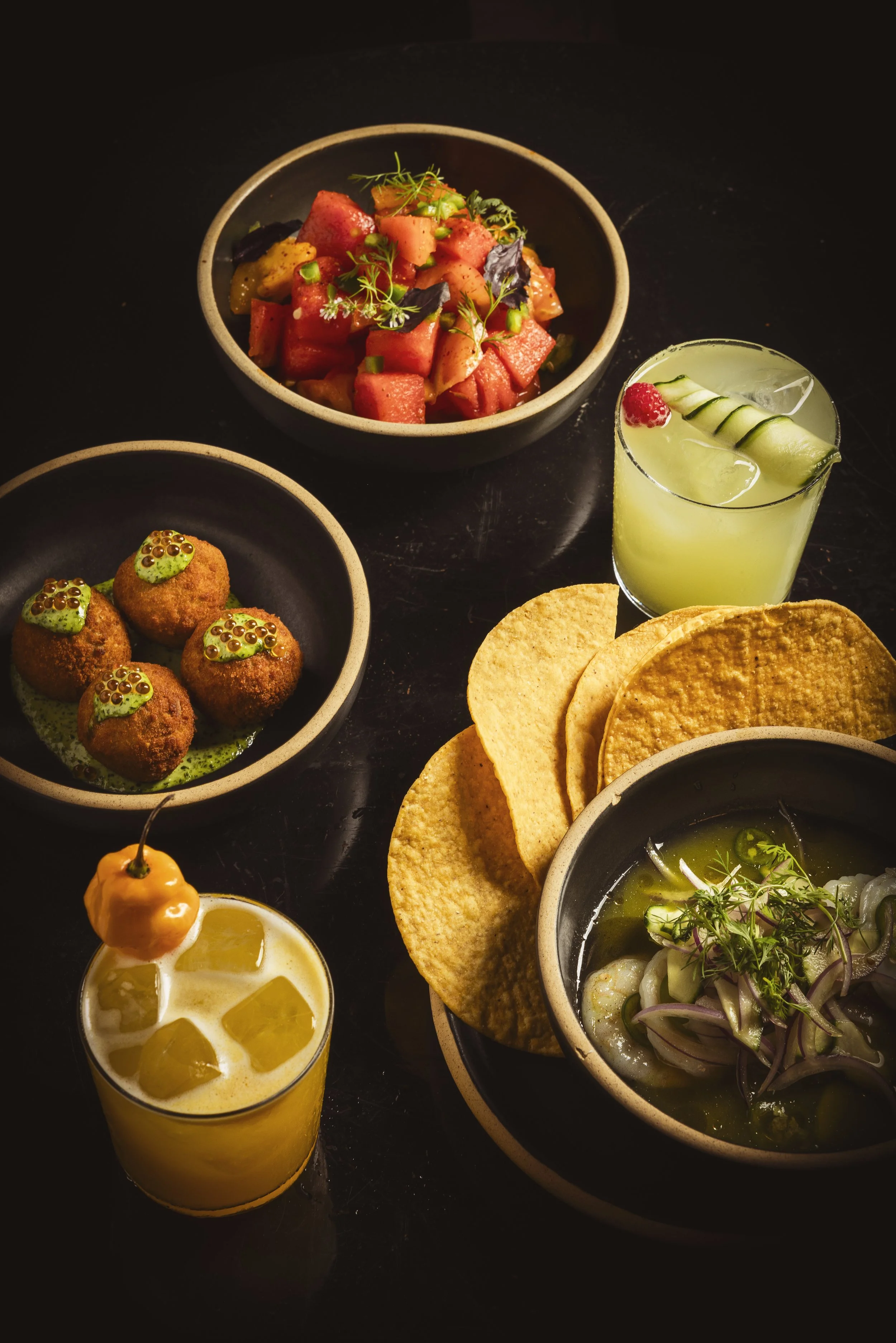 Daylight fills the dining room at GITANO NYC, where lush tropical plants, bohemian décor, and sweeping views of the Brooklyn Bridge create an elegant waterfront oasis.