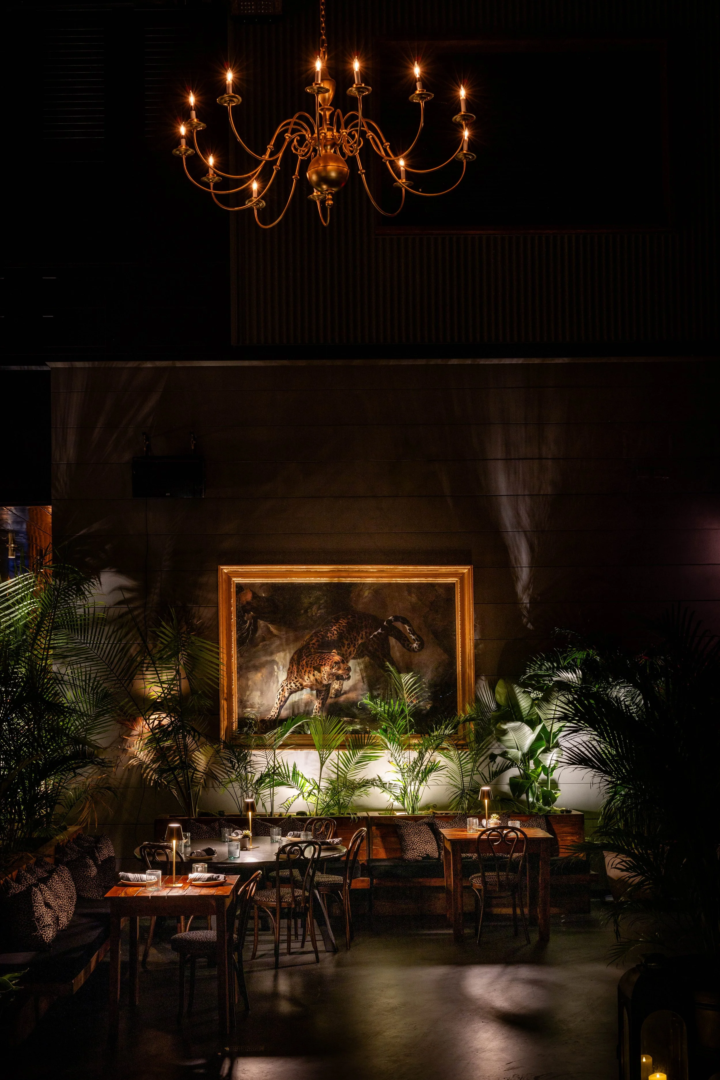 Daylight fills the dining room at GITANO NYC, where lush tropical plants, bohemian décor, and sweeping views of the Brooklyn Bridge create an elegant waterfront oasis.