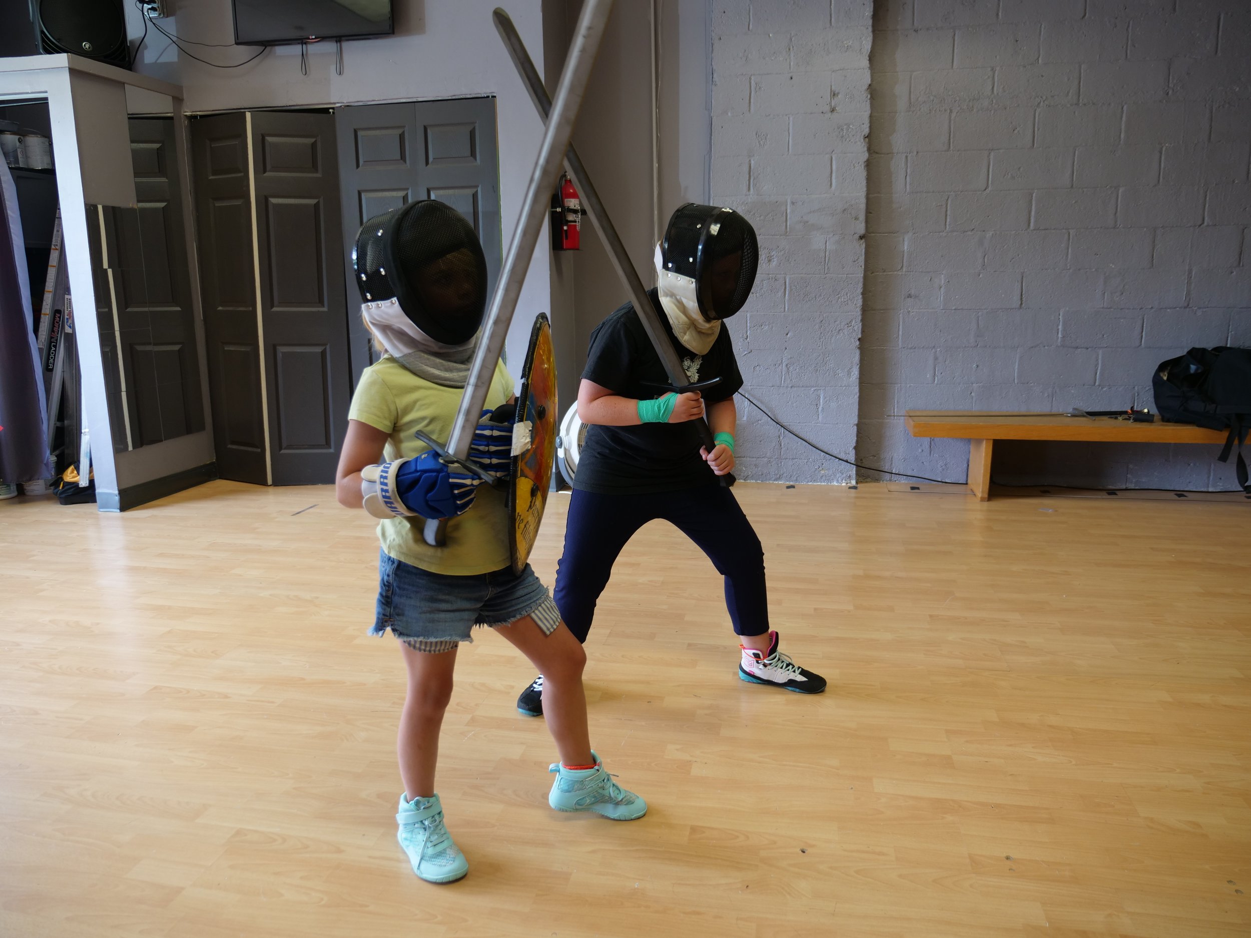 Kids ready to swordfight in their martial arts class