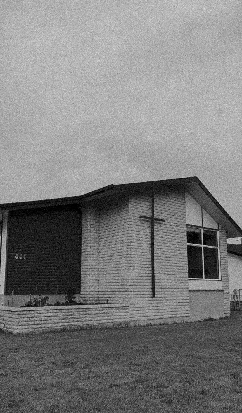 A modern single-story house with a brick exterior, large front windows, and a sloped roof, numbered 441, with a small yard in front.