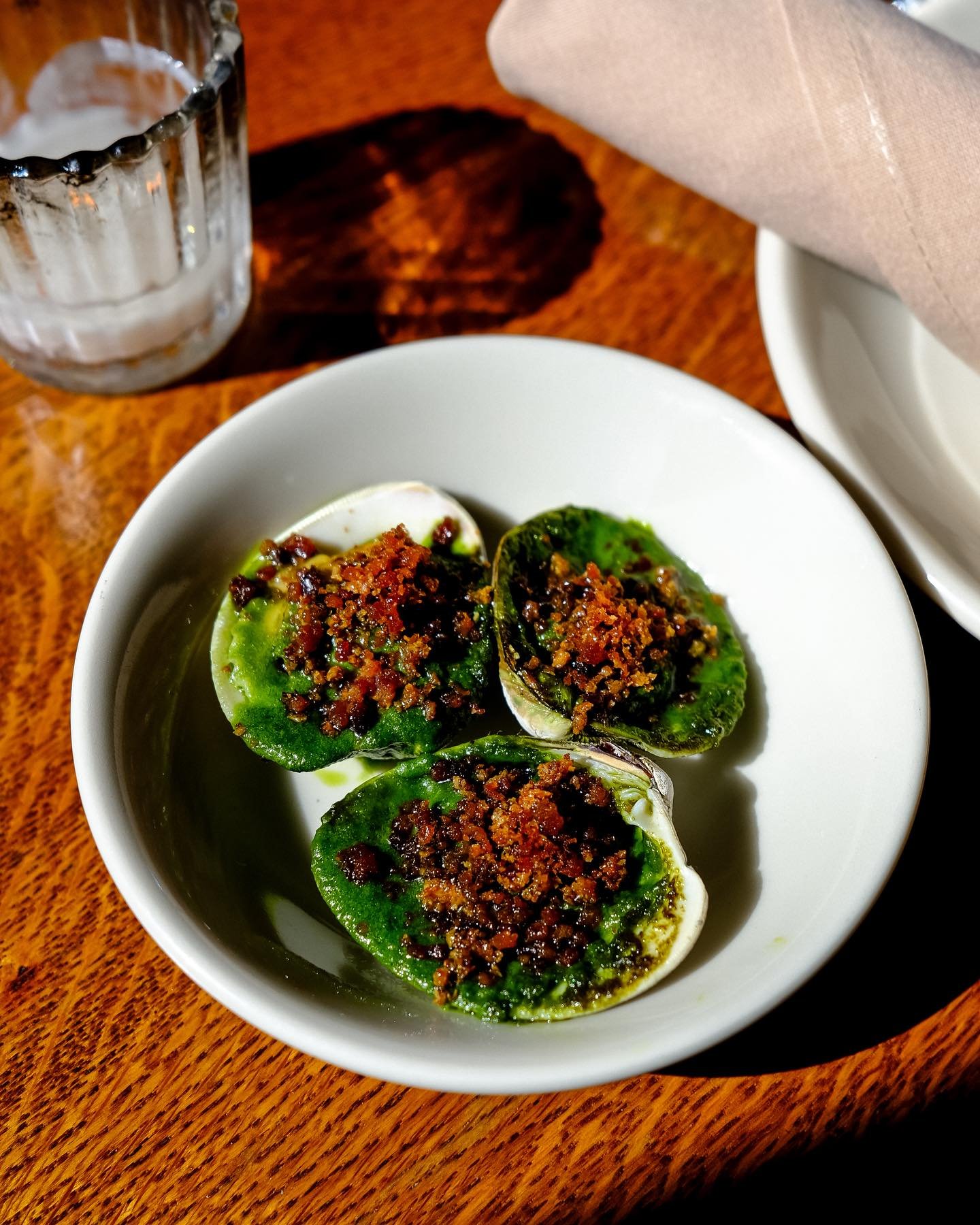 ⚡️clams casino⚡️ local littleneck clams, garlic parsley butter, absinthe, bacon + bread crumbs 💚