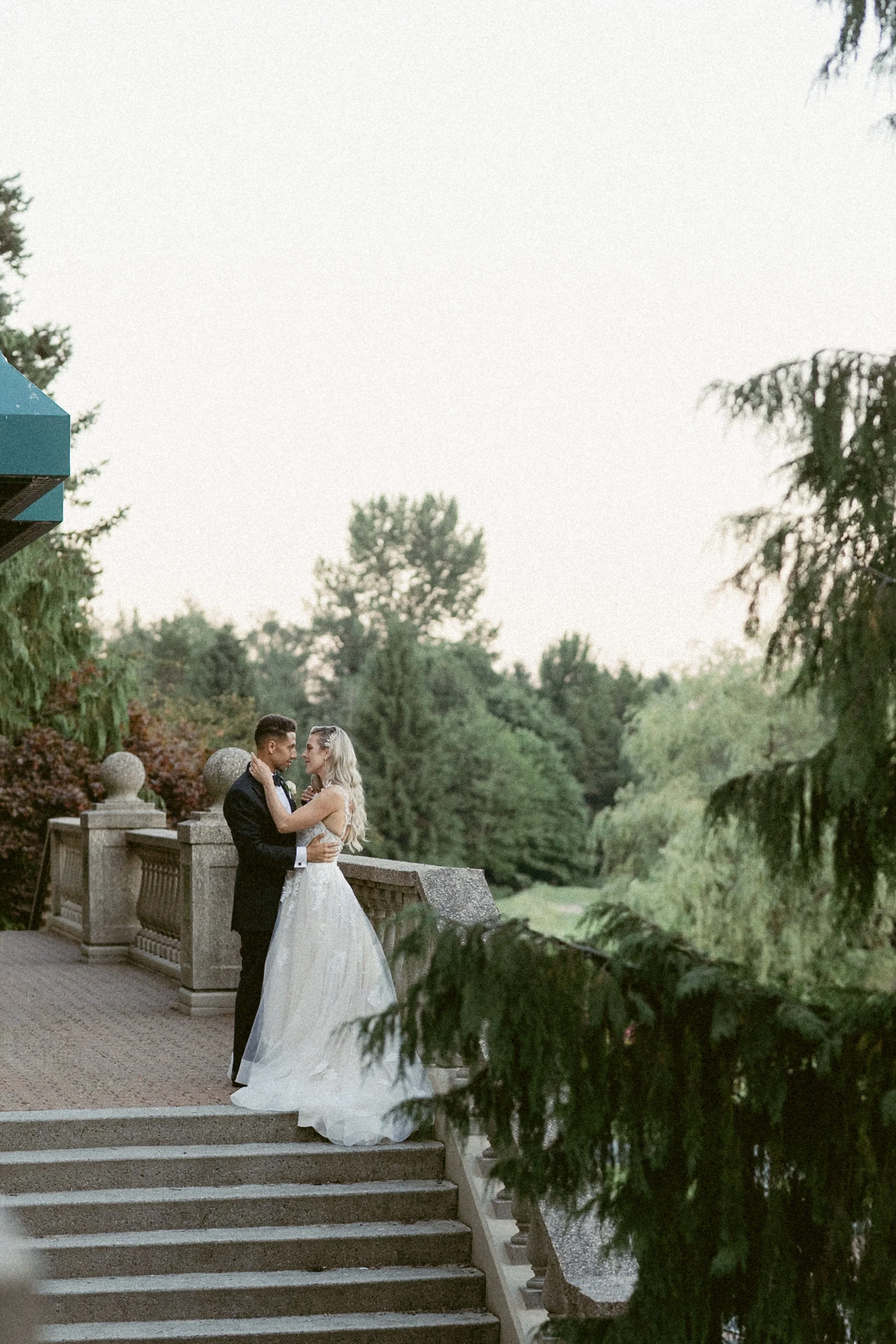Bride and groom embracing on an outdoor stone staircase at Swaneset Bay Resort.
