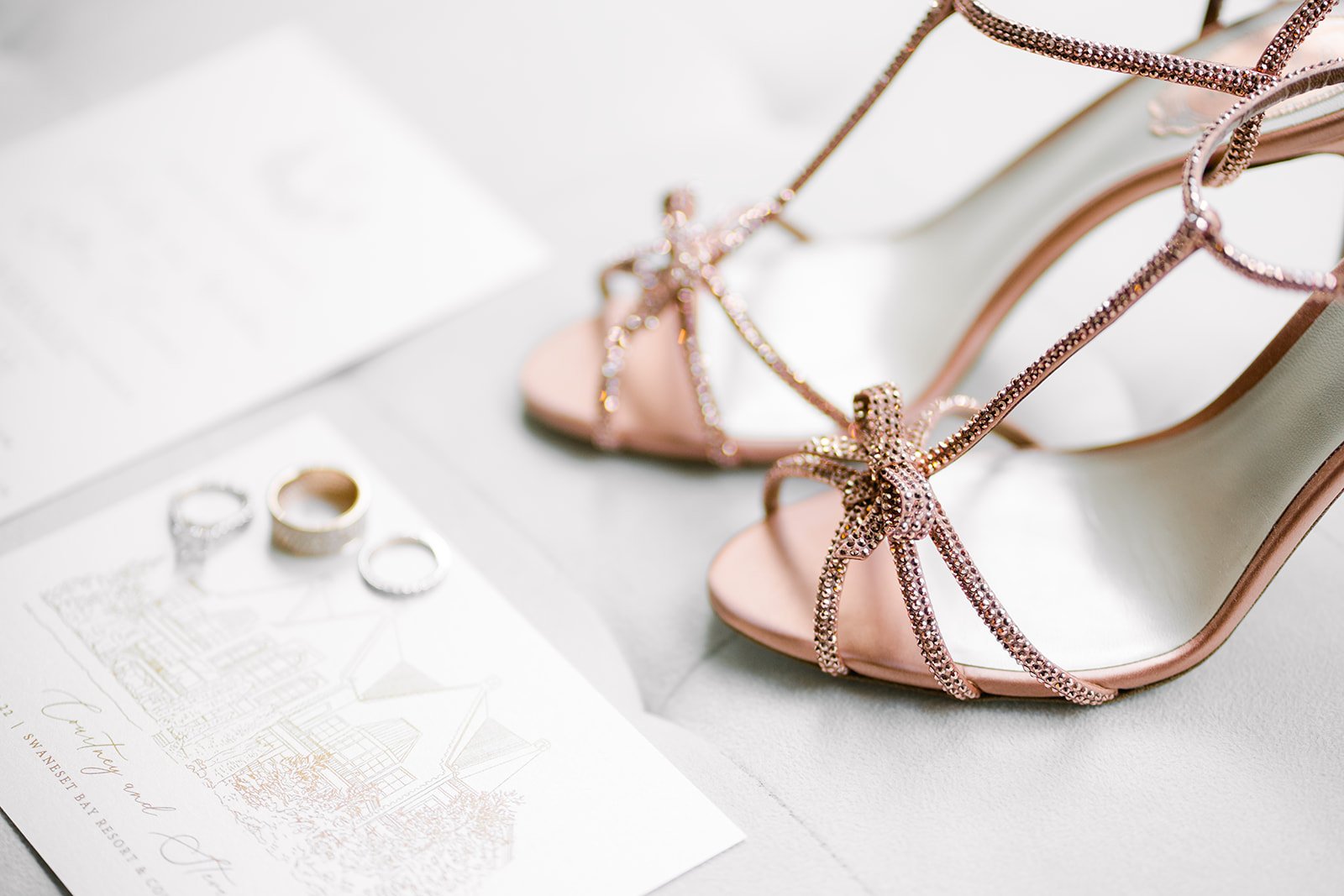 rene caovilla bridal shoes pose next to gold rings and invitations for Vancouver, BC wedding  