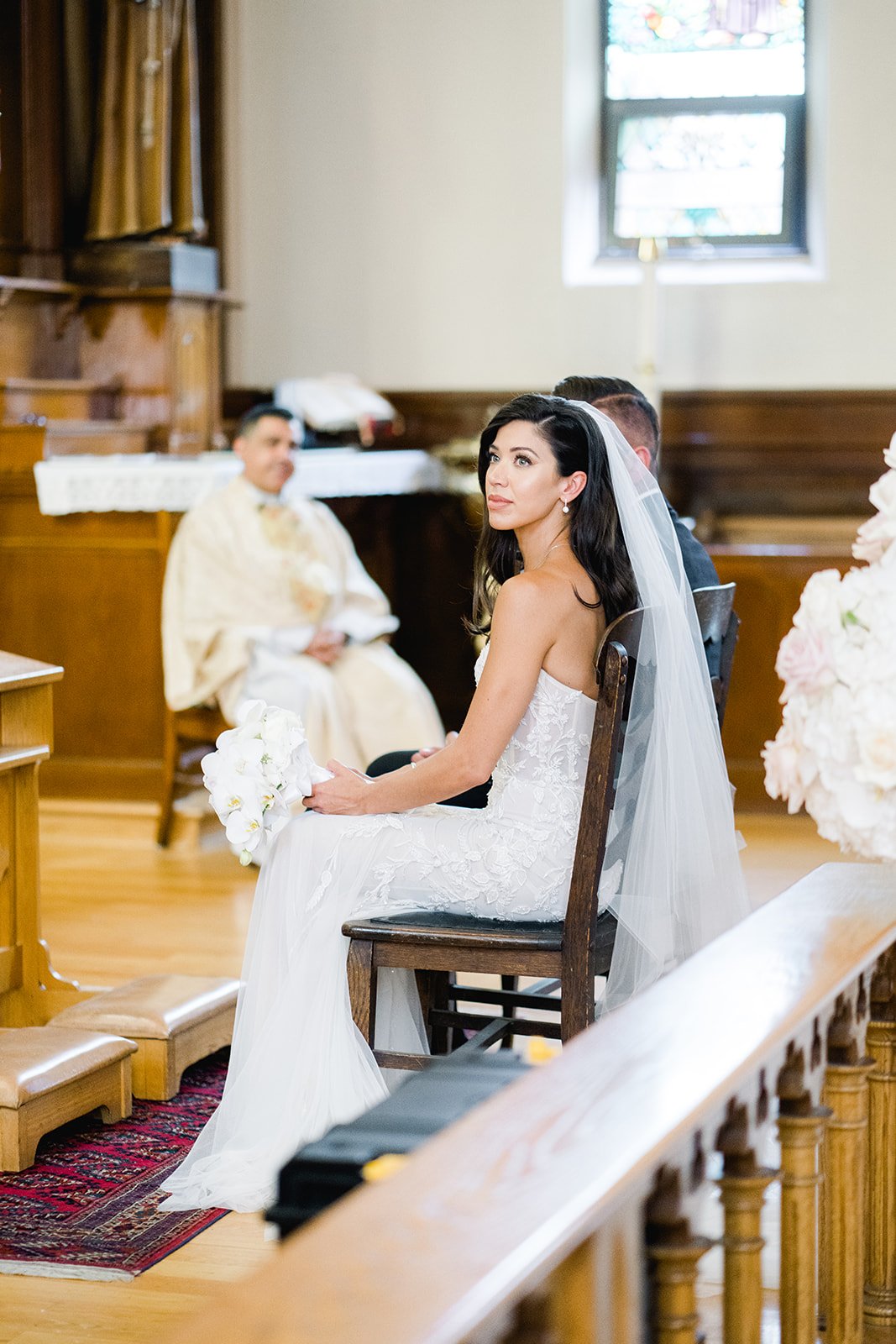 Beautiful Bride sits in Catholic Ceremony, at St. Francis of Assisi in Vancouver Canada 
