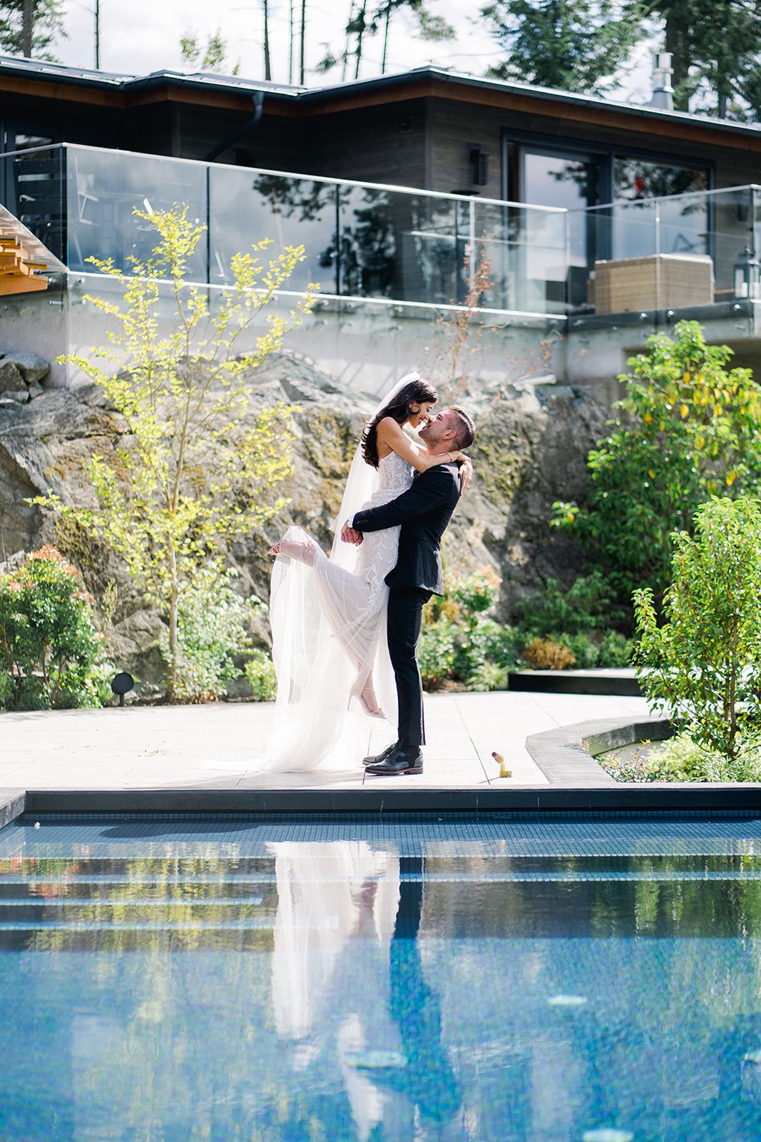 Groom lifts tiny glamorous bride in show of strength, while standing poolside in Vancouver, Canada