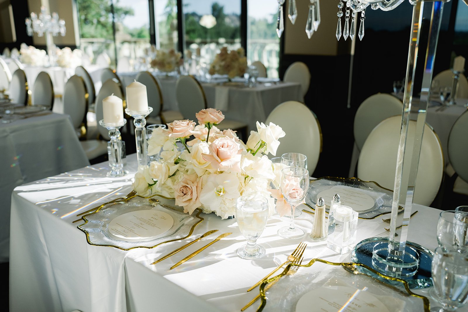 Luxe head table is adorned by by pink and white floral arrangement
