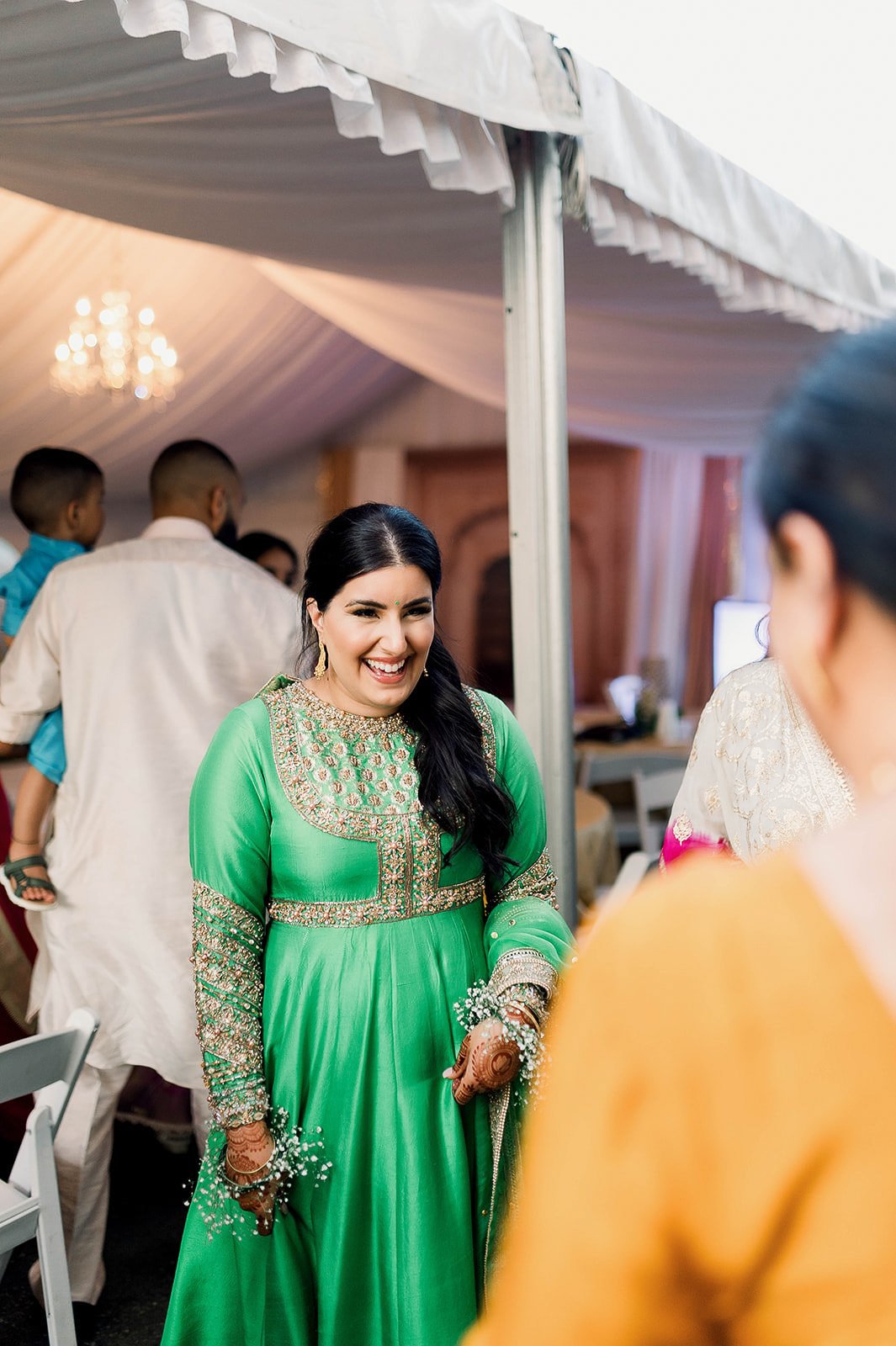 wedding guest dressed in a green sparkly anarkali during a wedding in Vancouver, BC. 