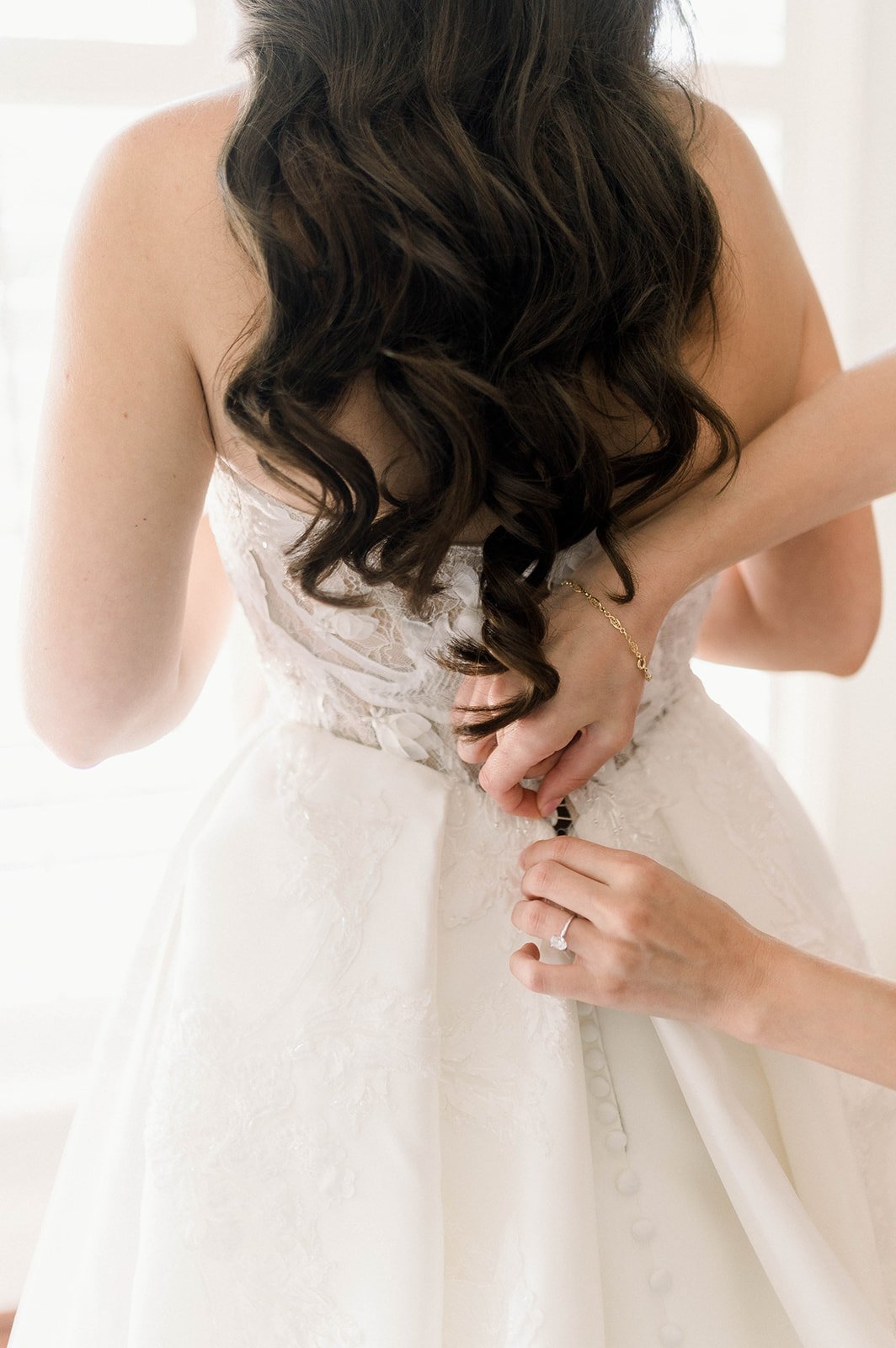 Brides mother helps bride into wedding dress at Hart House in Vancouver BC wedding.