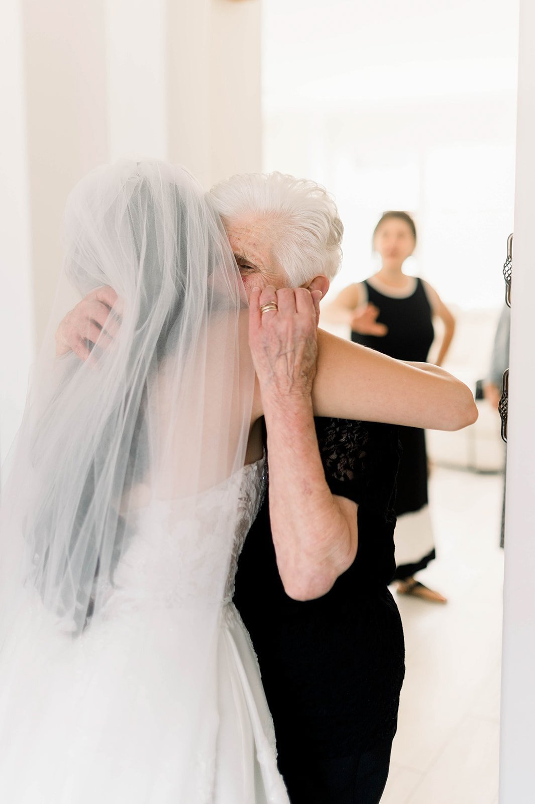 Grandmother hugs bride in loving embrace before hart house wedding ceremony. 