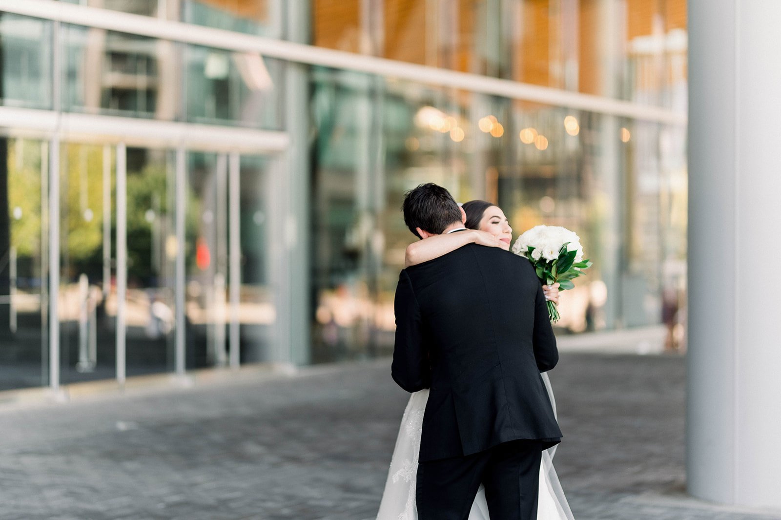Bride and groom embrace under the Vancouver Convention Centre before Hart House Wedding.