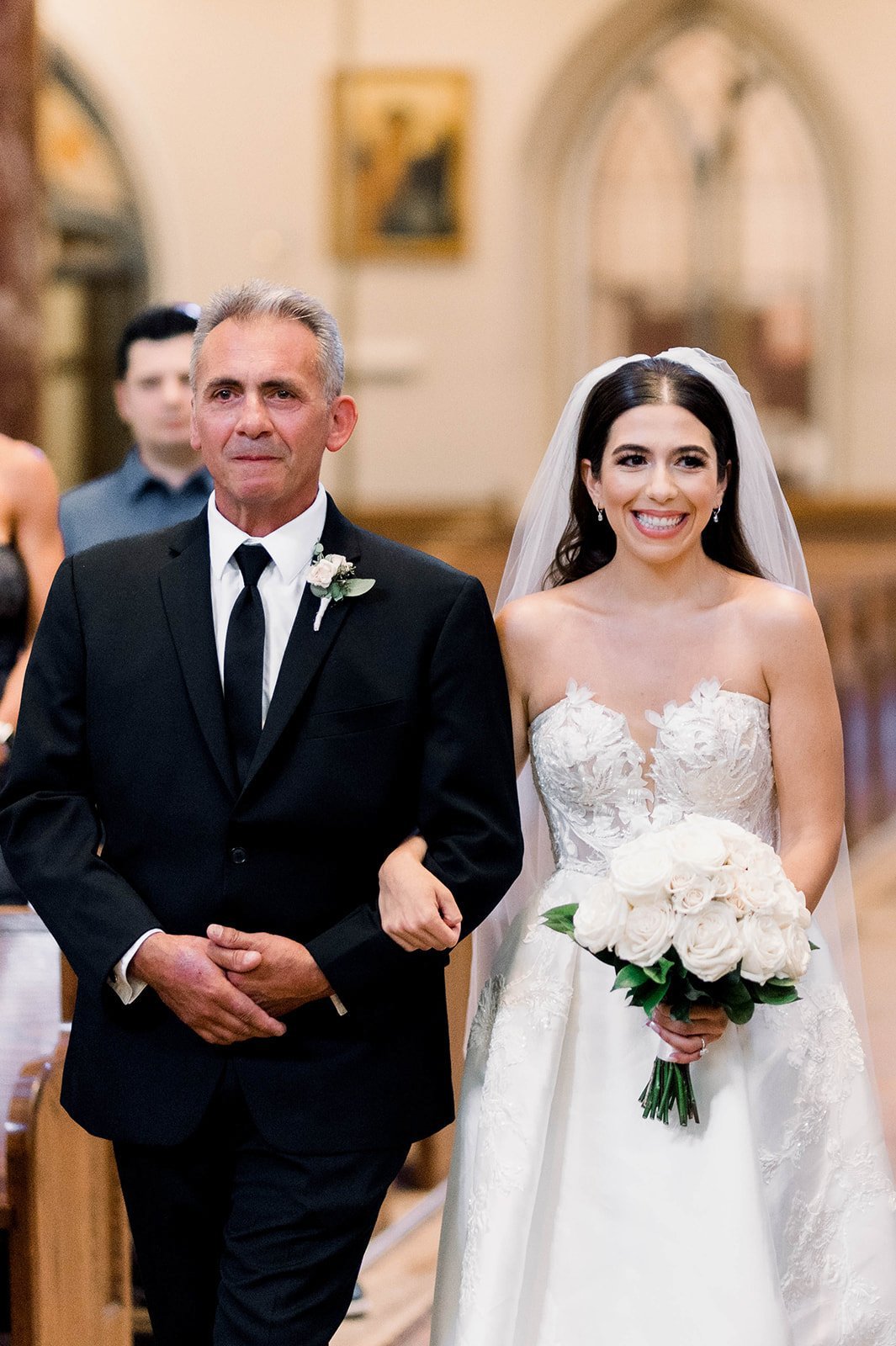Father of bride holds back tears as he approaches the end of the aisle